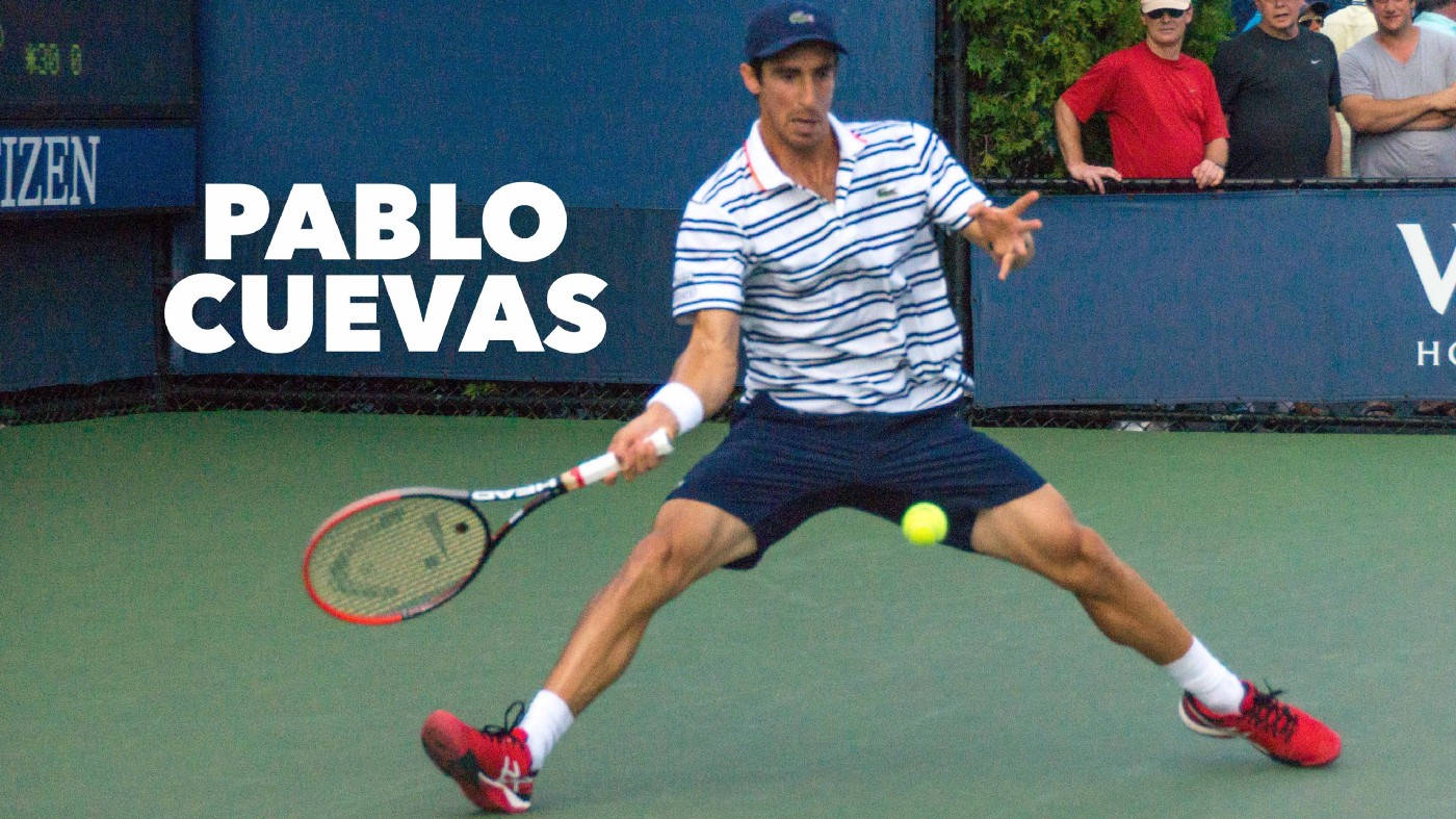 Athletic 桌布 壁紙 — 網球運動員Pablo Cuevas在綠色球場上向前猛衝，以高度專注力擊打黃色球。