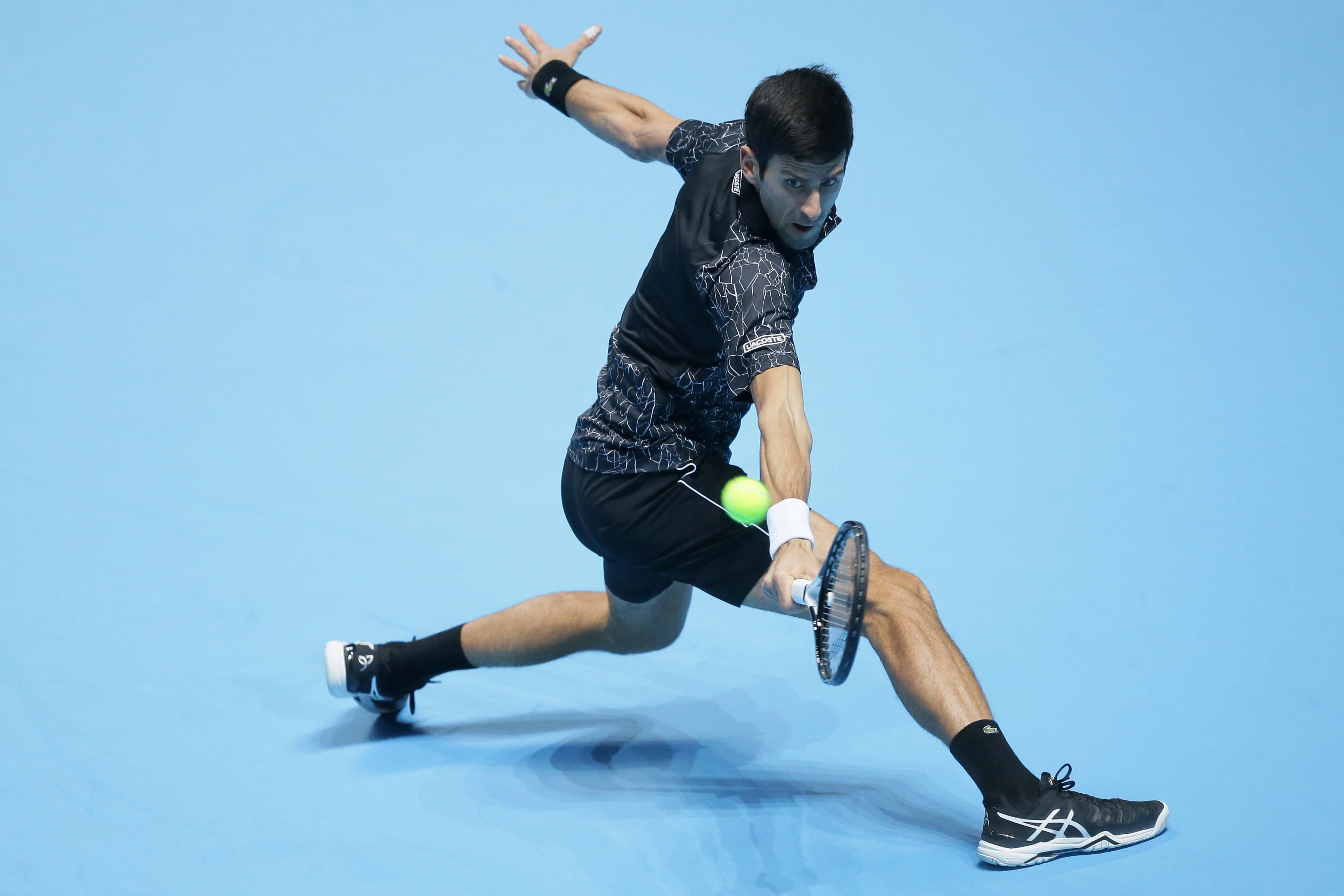 Novak 桌布 壁紙 — 網球運動員向前猛衝，專注地擊打一個明亮的黃色球在鮮豔的藍色球場上。