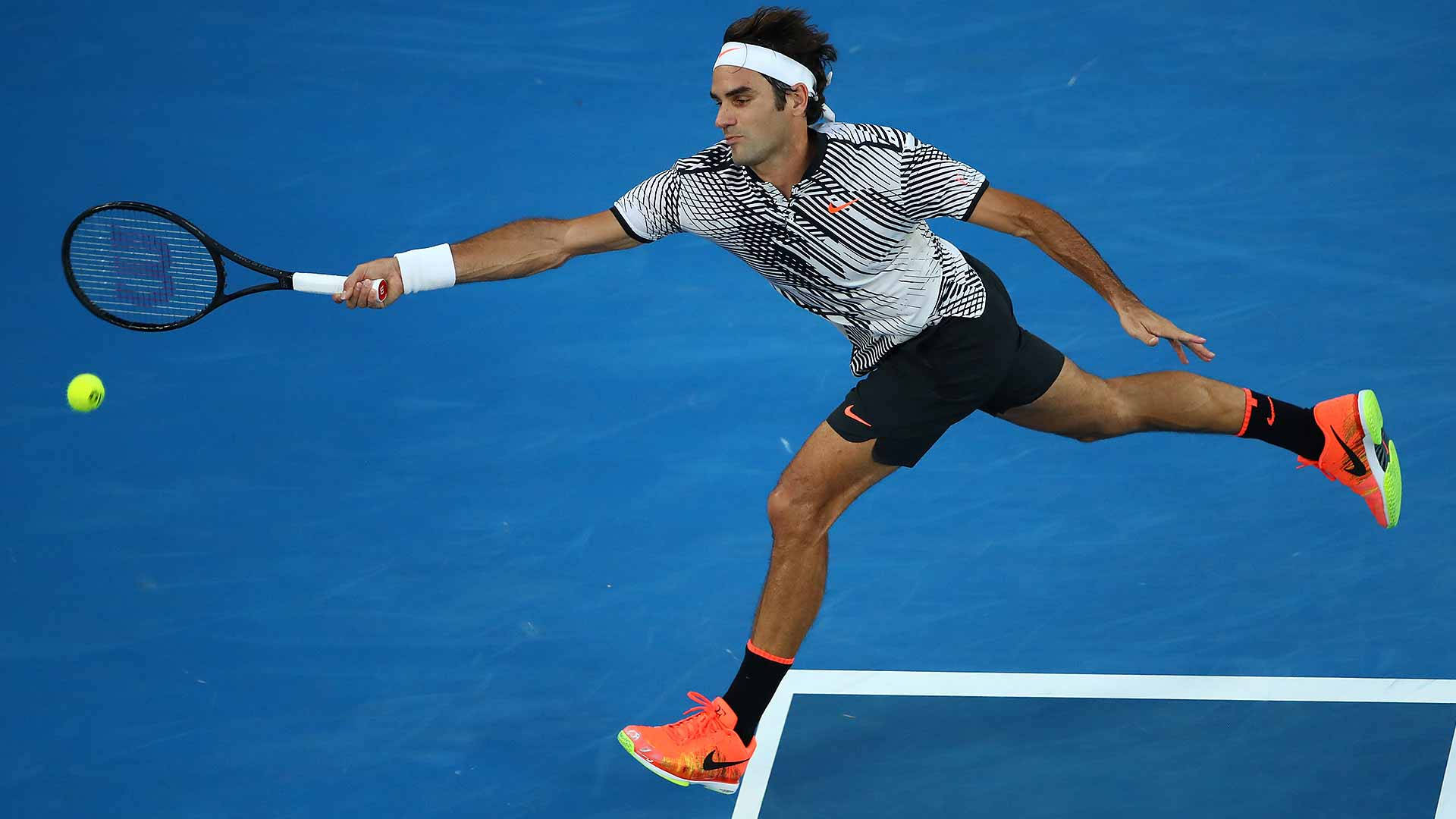 Australian Open 桌布 壁紙 — 網球運動員在充滿活力的藍色球場上動態地衝刺，以強烈的專注和運動優雅擊打黃色球。