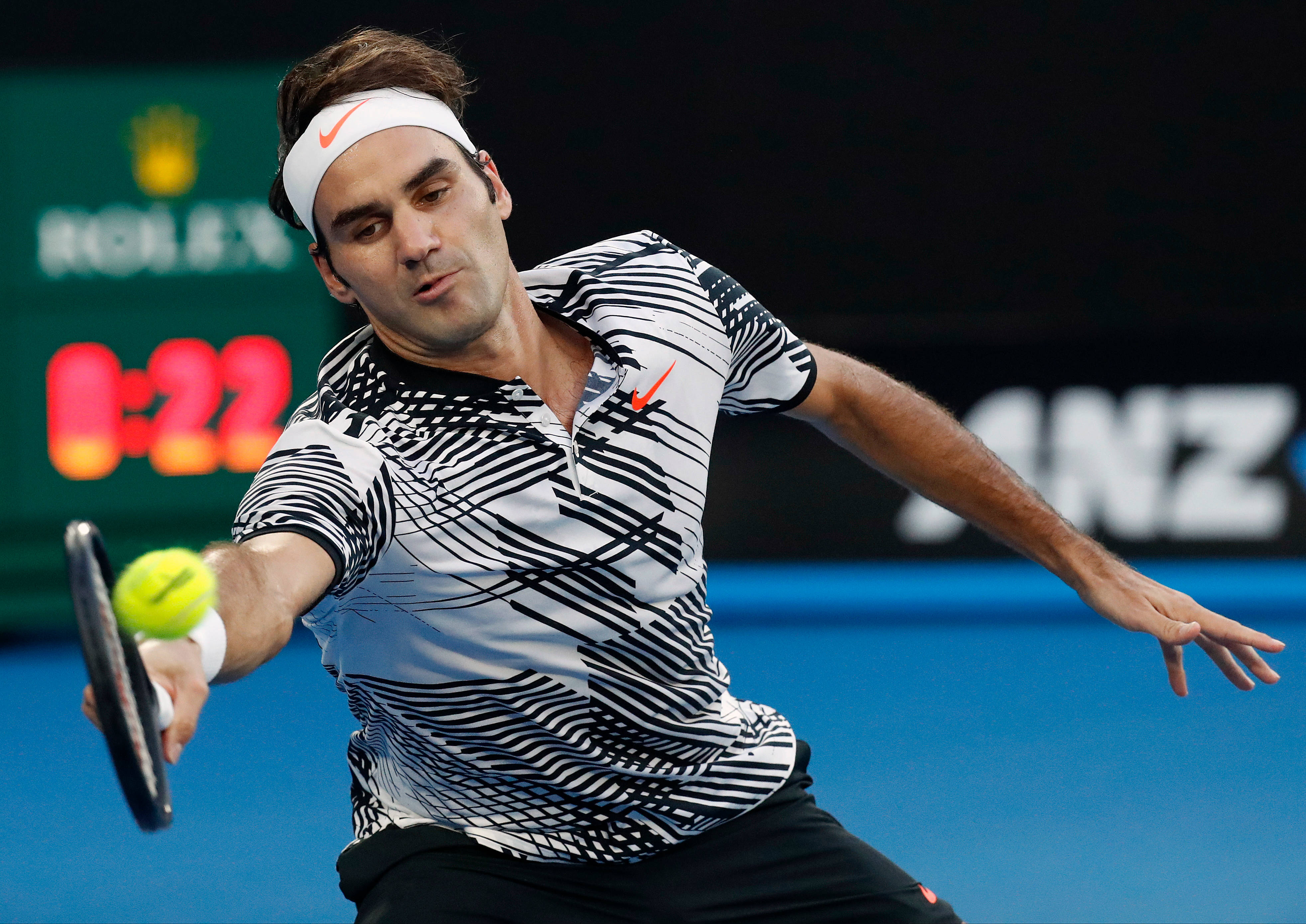 roger 桌布 壁紙 — 網球運動員羅傑·費德勒在明亮的體育場燈光下，在藍色硬地球場上揮拍擊出正手球的中間動作。