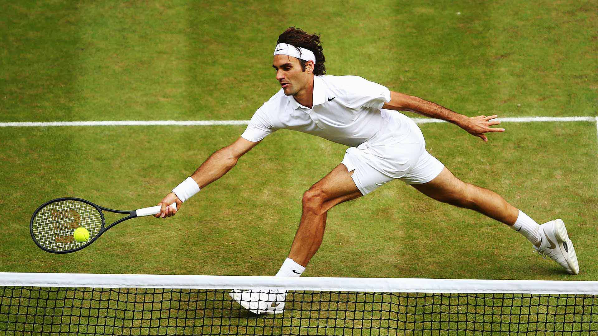 Wimbledon 桌布 壁紙 — 網球選手在草地場上向前猛衝，在網前擊出低平正手，專注力極強。