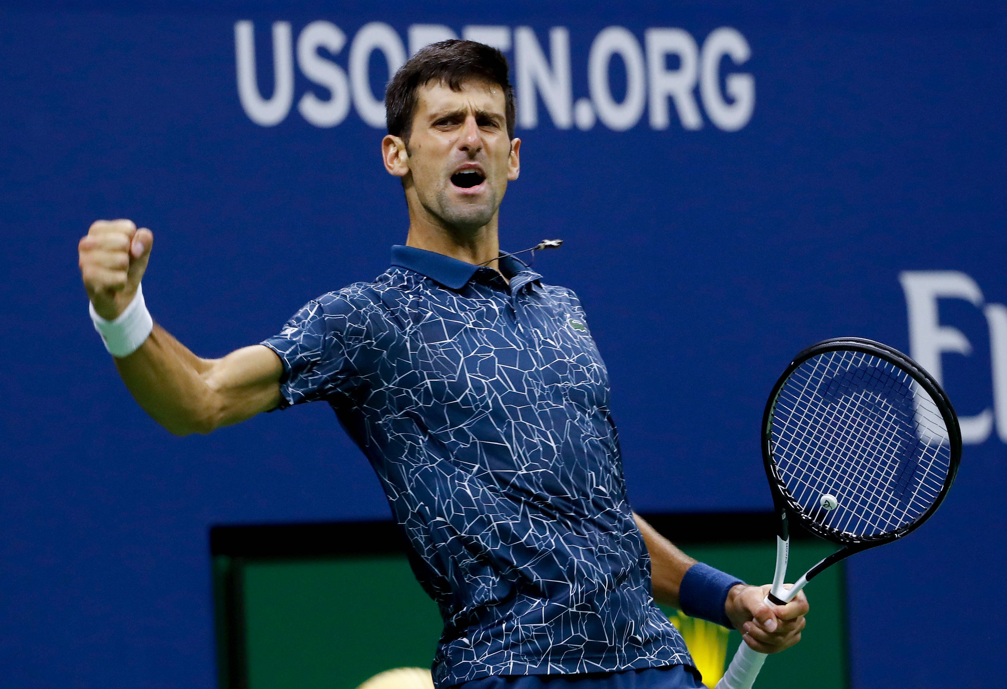 Novak 桌布 壁紙 — 網球選手諾瓦克·喬科維奇在藍色USOPEN.ORG背景下握緊拳頭和球拍慶祝勝利。