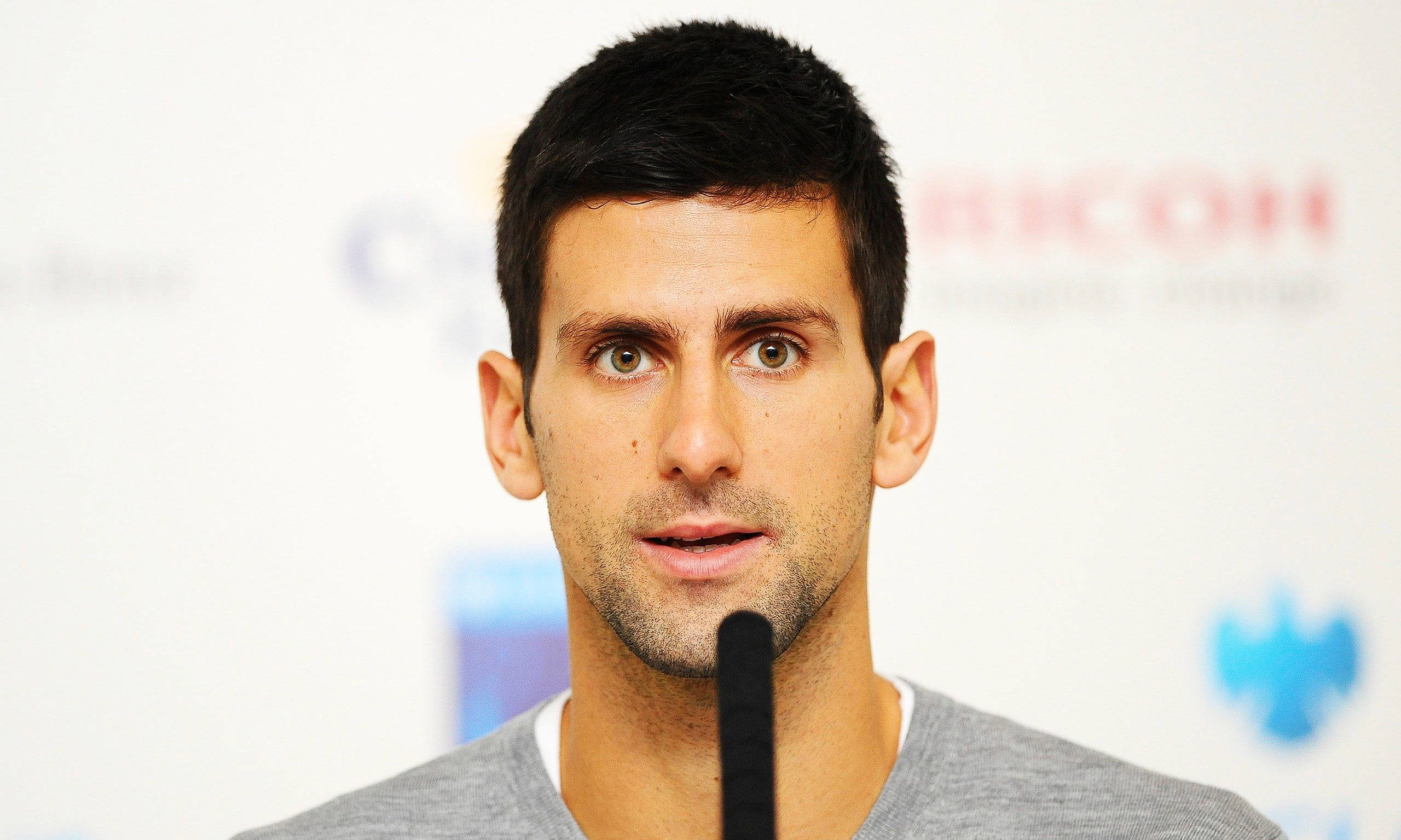 Novak 桌布 壁紙 — 網球選手諾瓦克·喬科維奇在記者會上發言的近距離肖像，面前有一個麥克風。