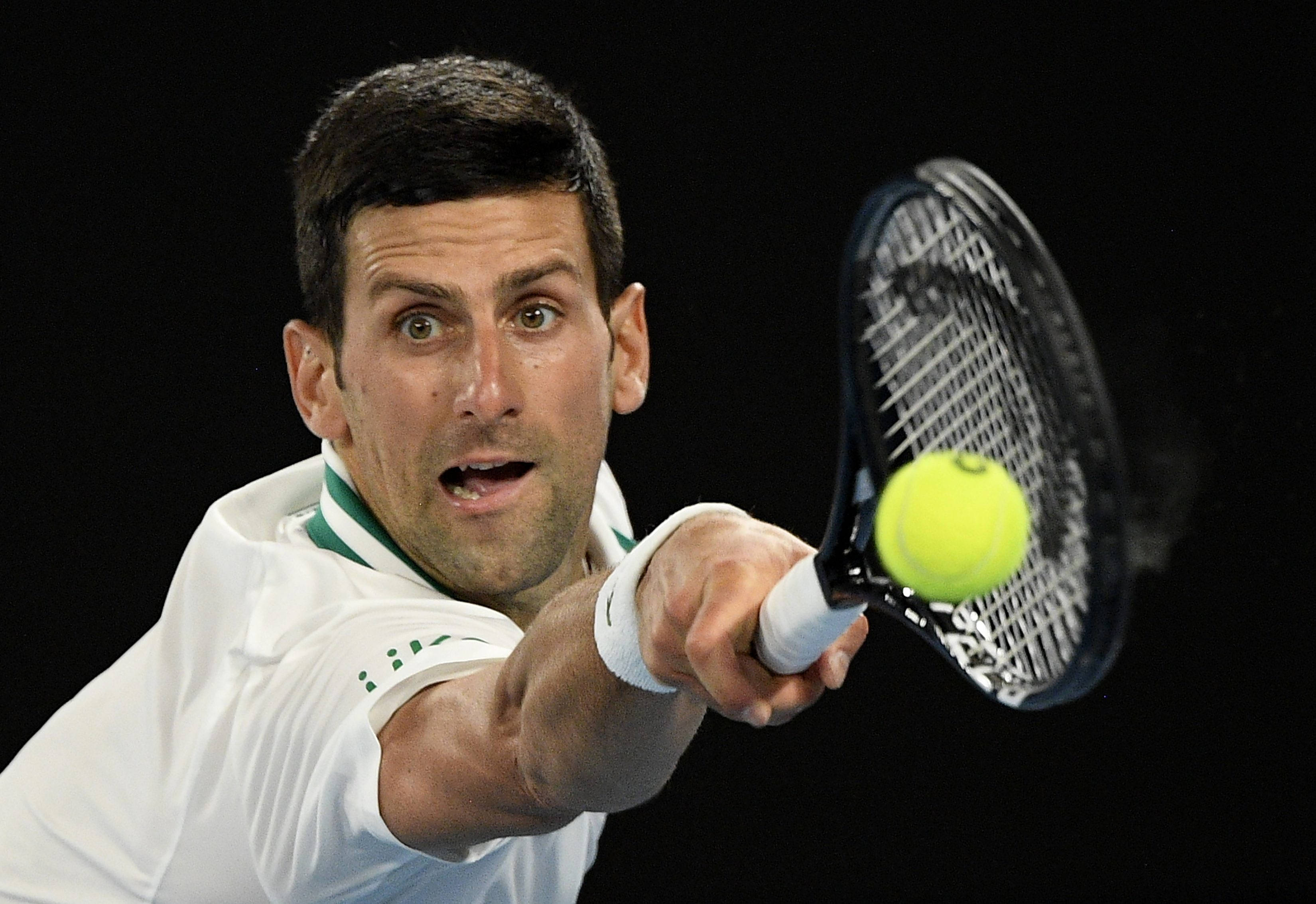 Australian Open 桌布 壁紙 — 網球選手諾瓦克·喬科維奇在黑色背景下用球拍猛烈擊打一個亮黃色的球。