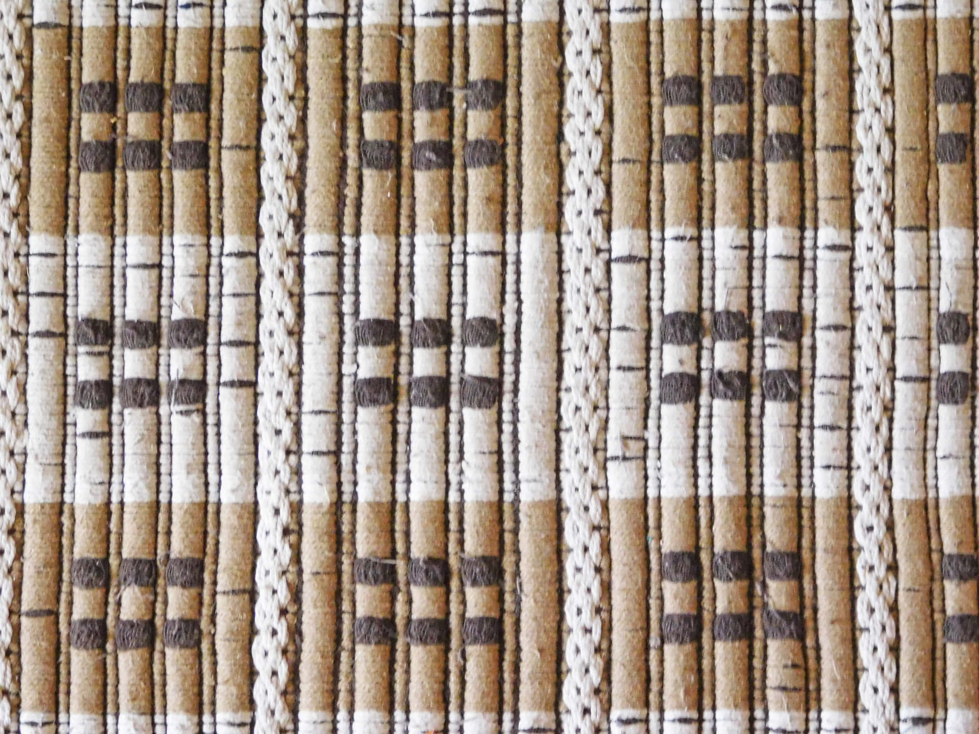 Carpet texture 壁紙 — 編織紡織品的特寫，帶有米色、棕色和白色條紋以及深色幾何圖案。