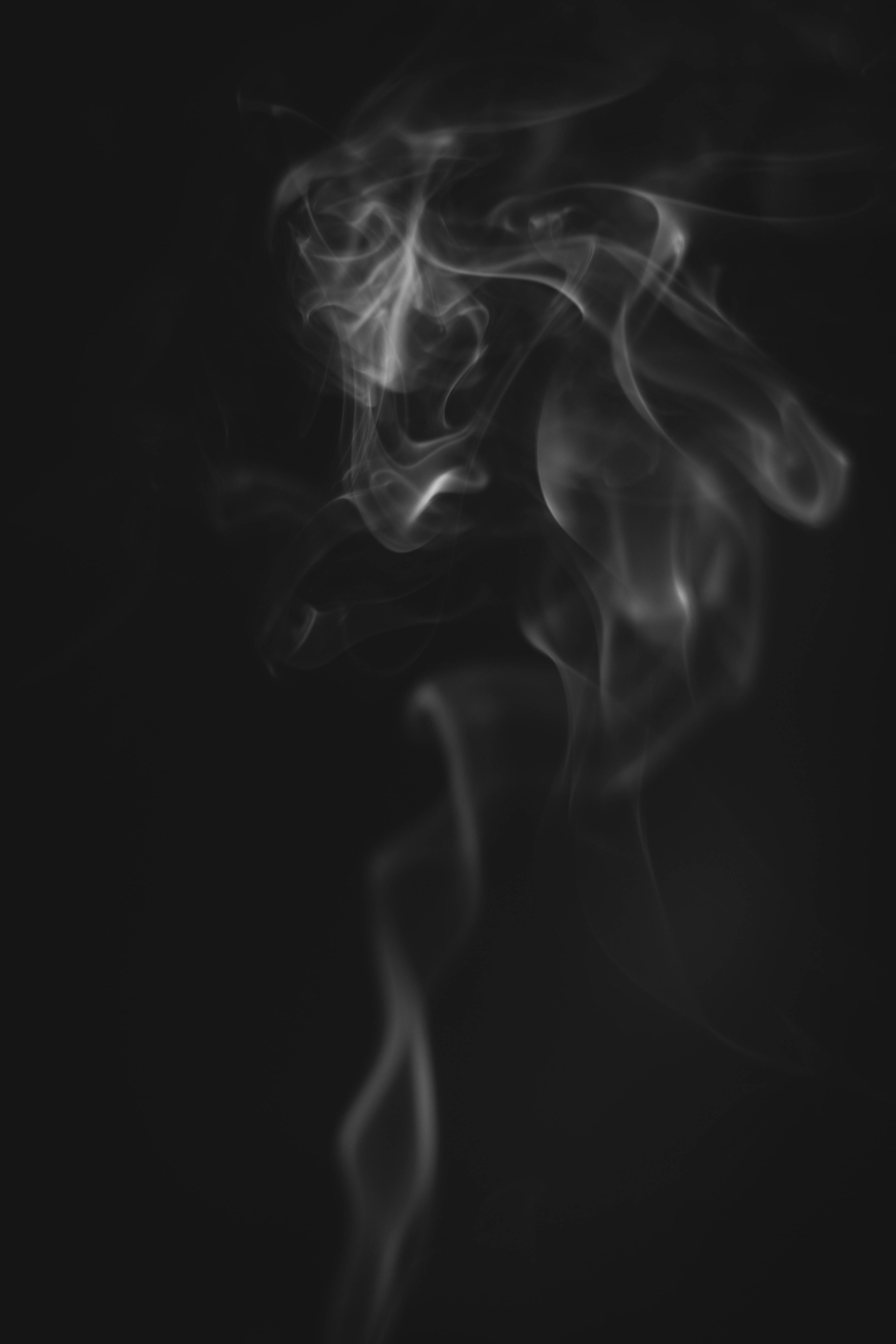 手機 桌布 壁紙 — 縹緲的煙霧縷縷在深黑色背景上彎曲扭轉，形成單色抽象舞蹈。