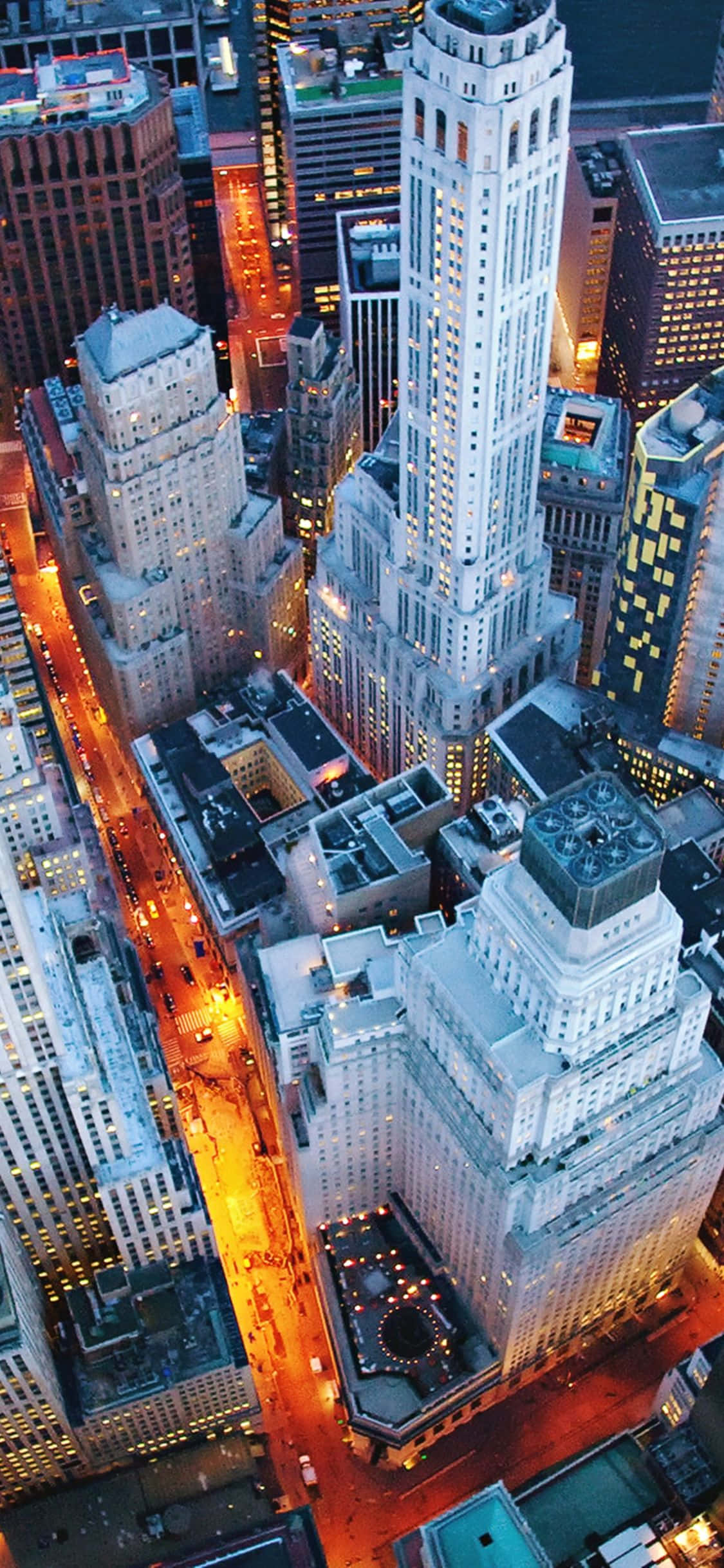iPhone Xs Ny City 桌布 壁紙 — 繁忙城市夜晚的鳥瞰圖，街道閃爍，高聳的摩天大樓燈火通明。