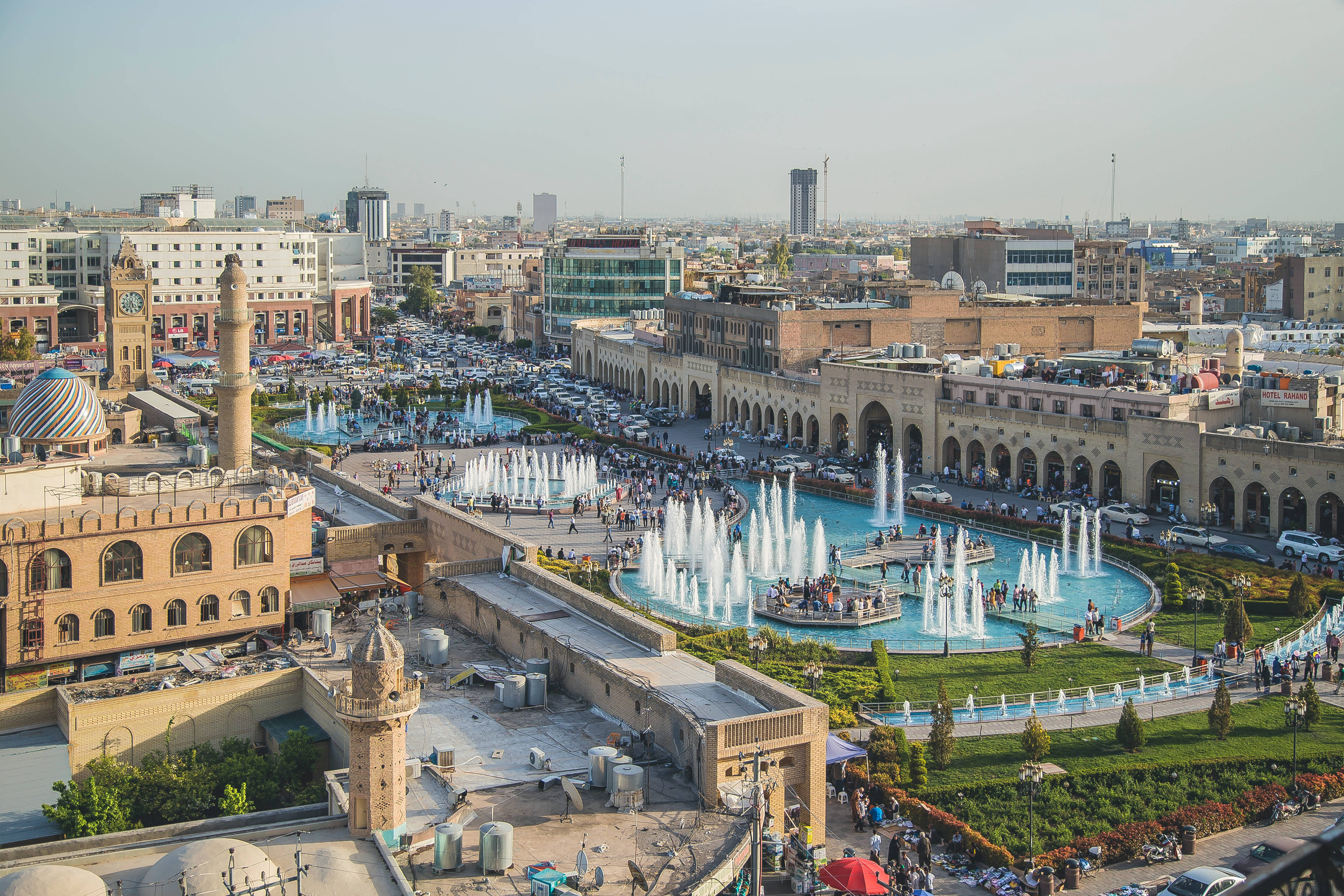 Iraq 桌布 壁紙 — 繁忙城市廣場的鳥瞰圖，廣場上有一個大型噴泉，周圍環繞著歷史建築和繁忙的街道。