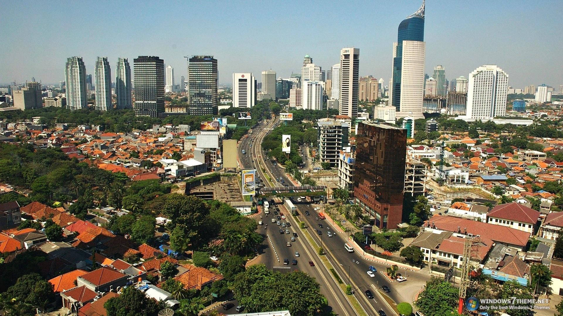 Jakarta 桌布 壁紙 — 繁忙城市景觀的鳥瞰圖，現代摩天大樓聳立在紅瓦住宅區和繁忙的高速公路上方。