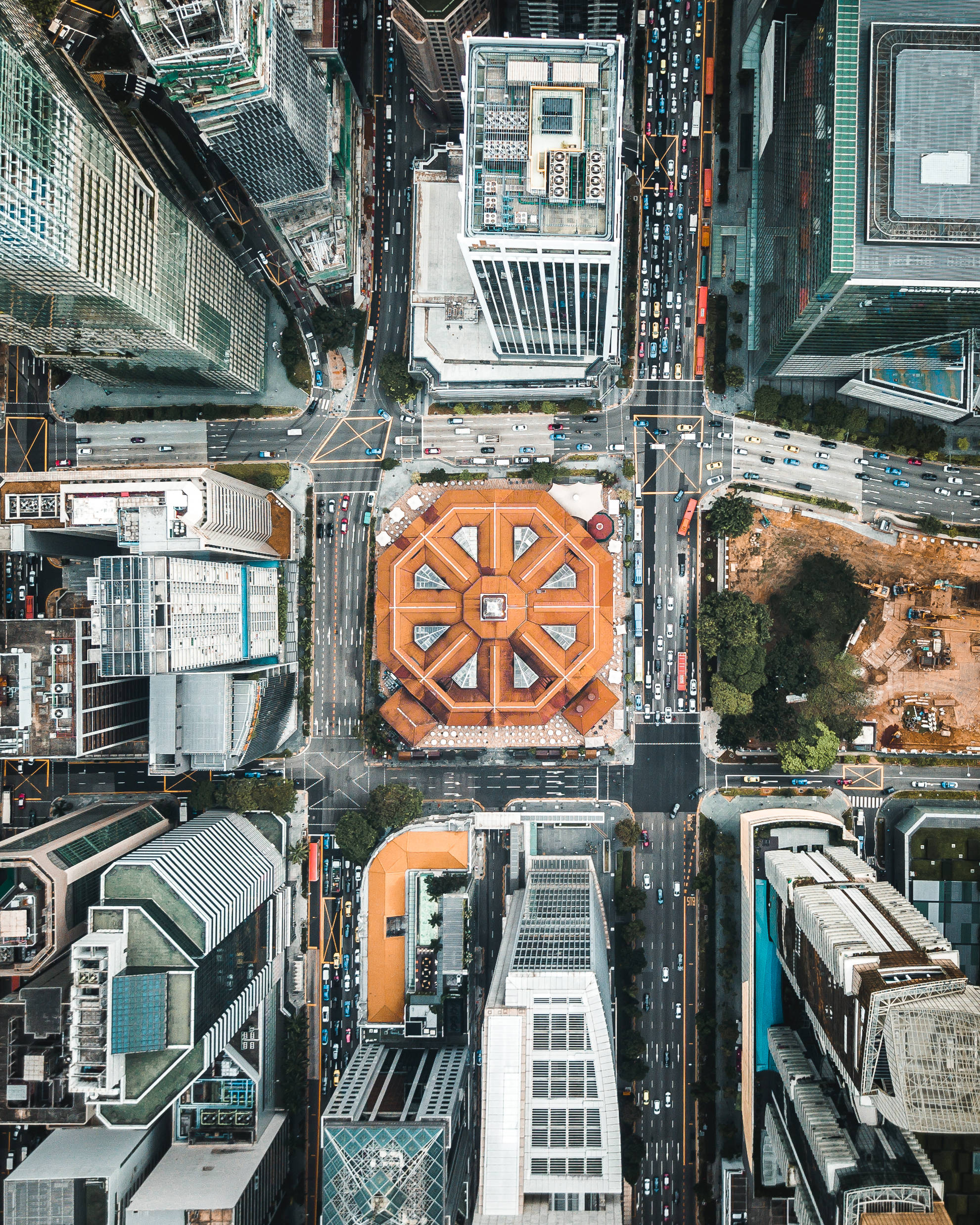 Singapore 桌布 壁紙 — 繁忙城市網格的鳥瞰圖，在主要交叉路口有一座獨特的橙色八角形建築。