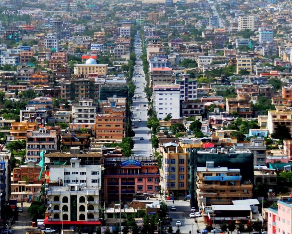 Afghanistan 桌布 壁紙 — 繁忙城市街道的鳥瞰圖，兩旁是色彩繽紛的建築物和綠化，在明亮的日光下。