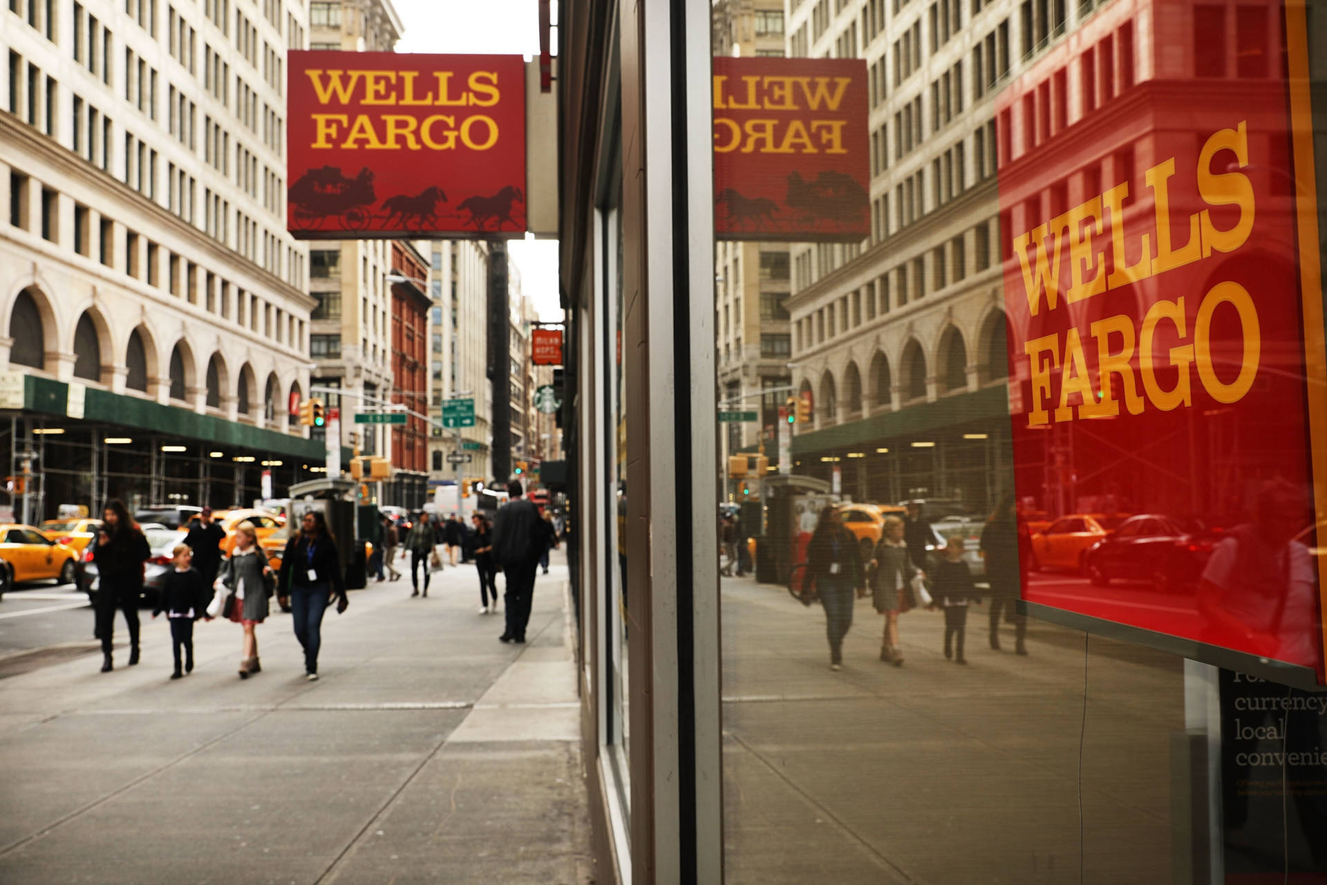 復古 桌布 壁紙 — 繁忙的城市人行道上，行人經過 Wells Fargo 銀行，其紅色標誌映照在玻璃窗上，反射出黃色的士和高樓大廈。