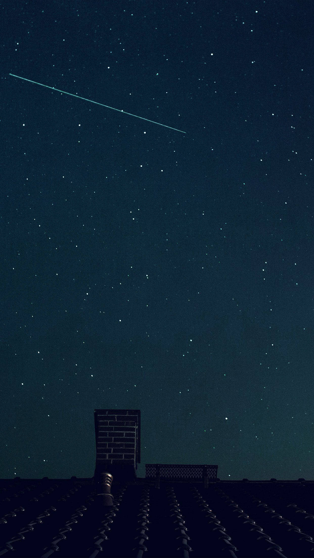 Blue Sky 桌布 壁紙 — 繁星點點的夜空，一顆明亮的流星劃過黑暗的瓦片屋頂和磚砌煙囪上方。