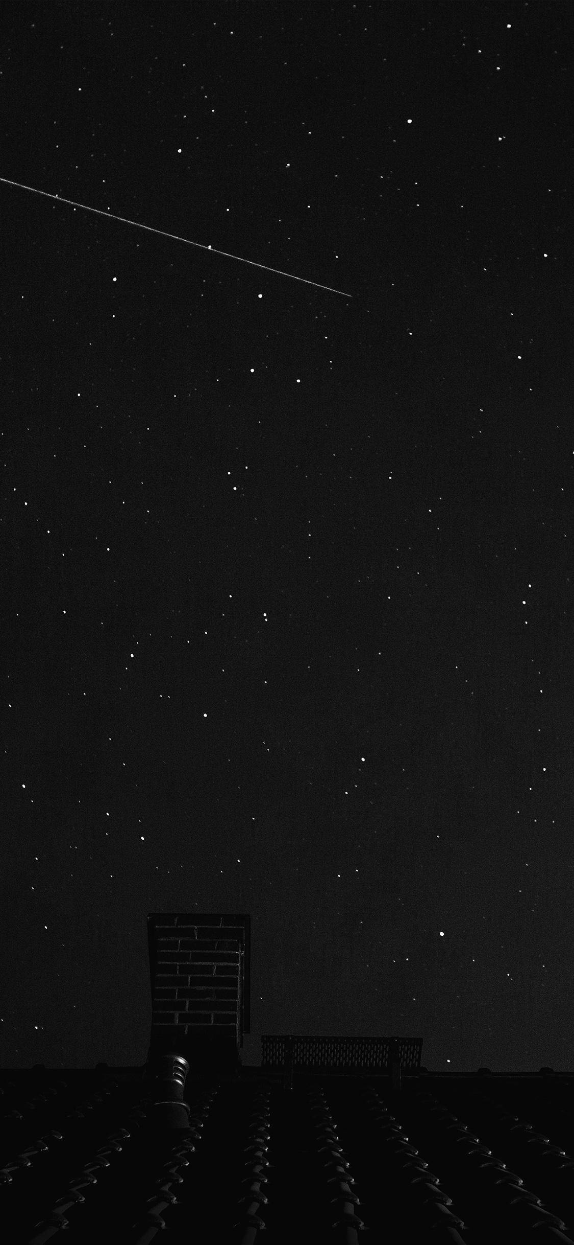 美學 iPhone 壁紙 桌布 壁紙 — 繁星點點的夜空，一顆明亮的流星劃過黑暗的屋頂煙囪上方。
