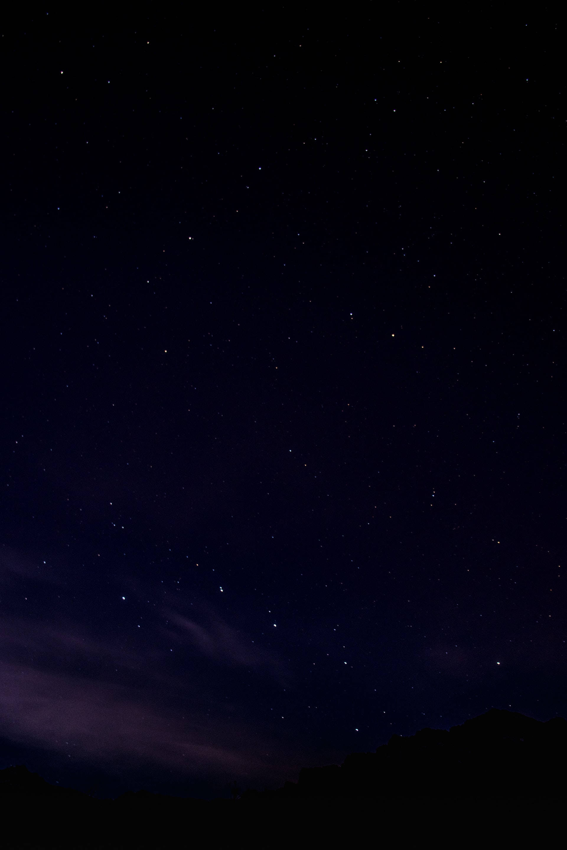 black aesthetic tumblr iPhone 桌布 壁紙 — 繁星點點的夜空，帶有深紫色雲朵和下方輪廓分明的山巒。