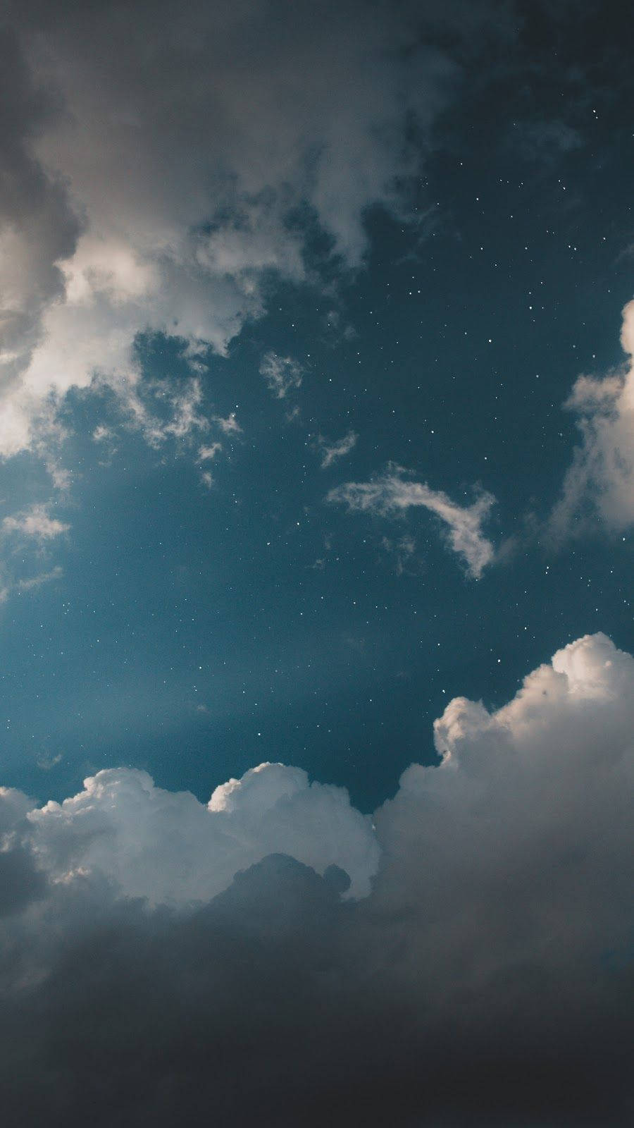 WhatsApp 聊天 桌布 壁紙 — 繁星點點的夜空，柔軟的雲朵飄過深藍綠色的廣闊天際，在天光下微微發光。
