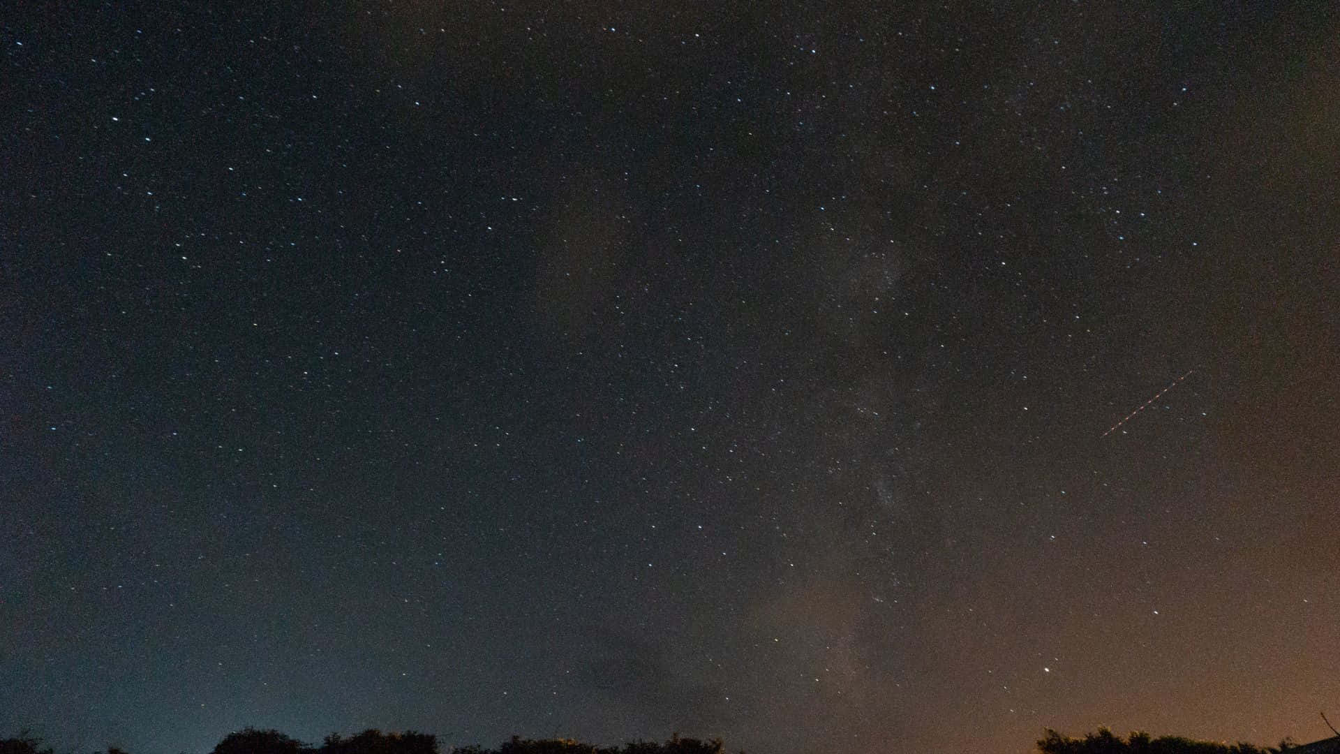 星空動畫 桌布 壁紙 — 繁星點點的夜空，銀河和流星在黑暗的樹線上拱起。