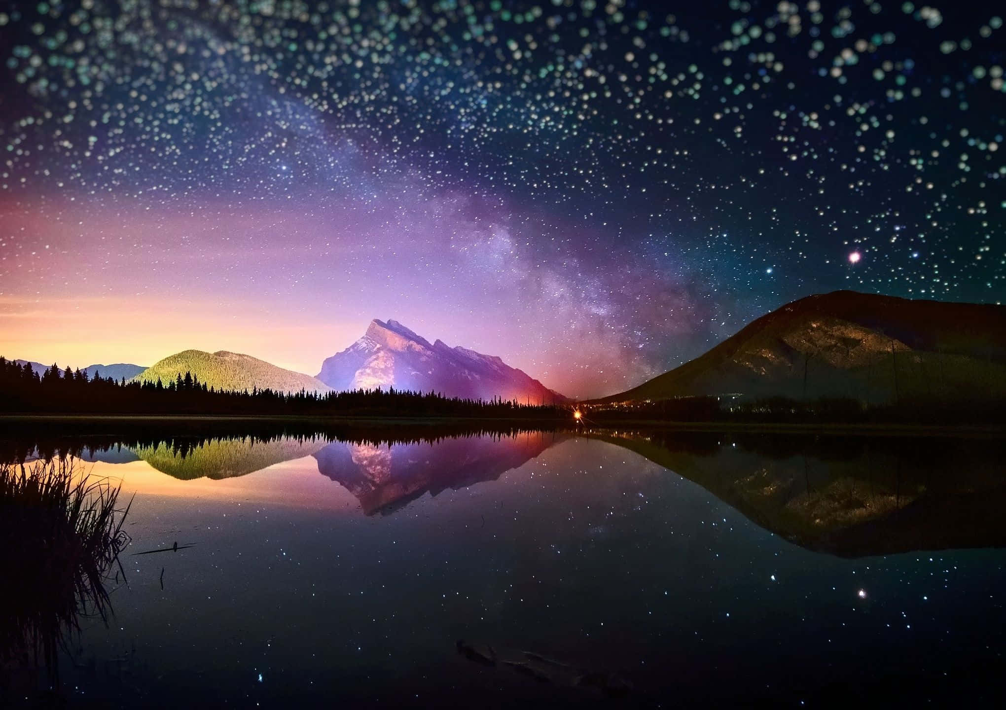 Starry Sky 桌布 壁紙 — 繁星點點的夜空，銀河拱起在積雪的山峰之上，倒映在平靜的湖面上。