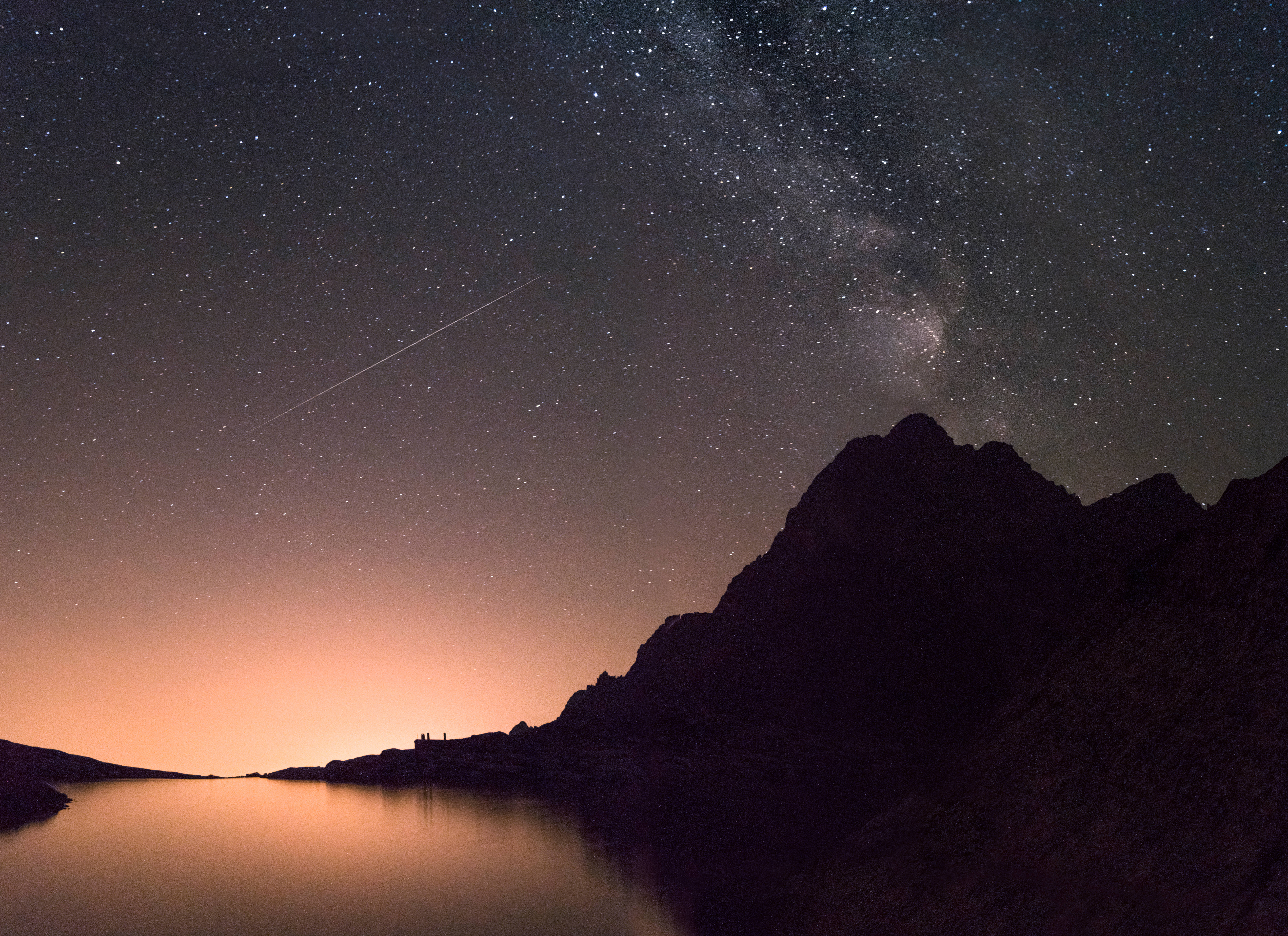 google 桌布 壁紙 — 繁星點點的夜空，銀河拱跨平靜的湖泊和鋸齒狀的山巒輪廓。