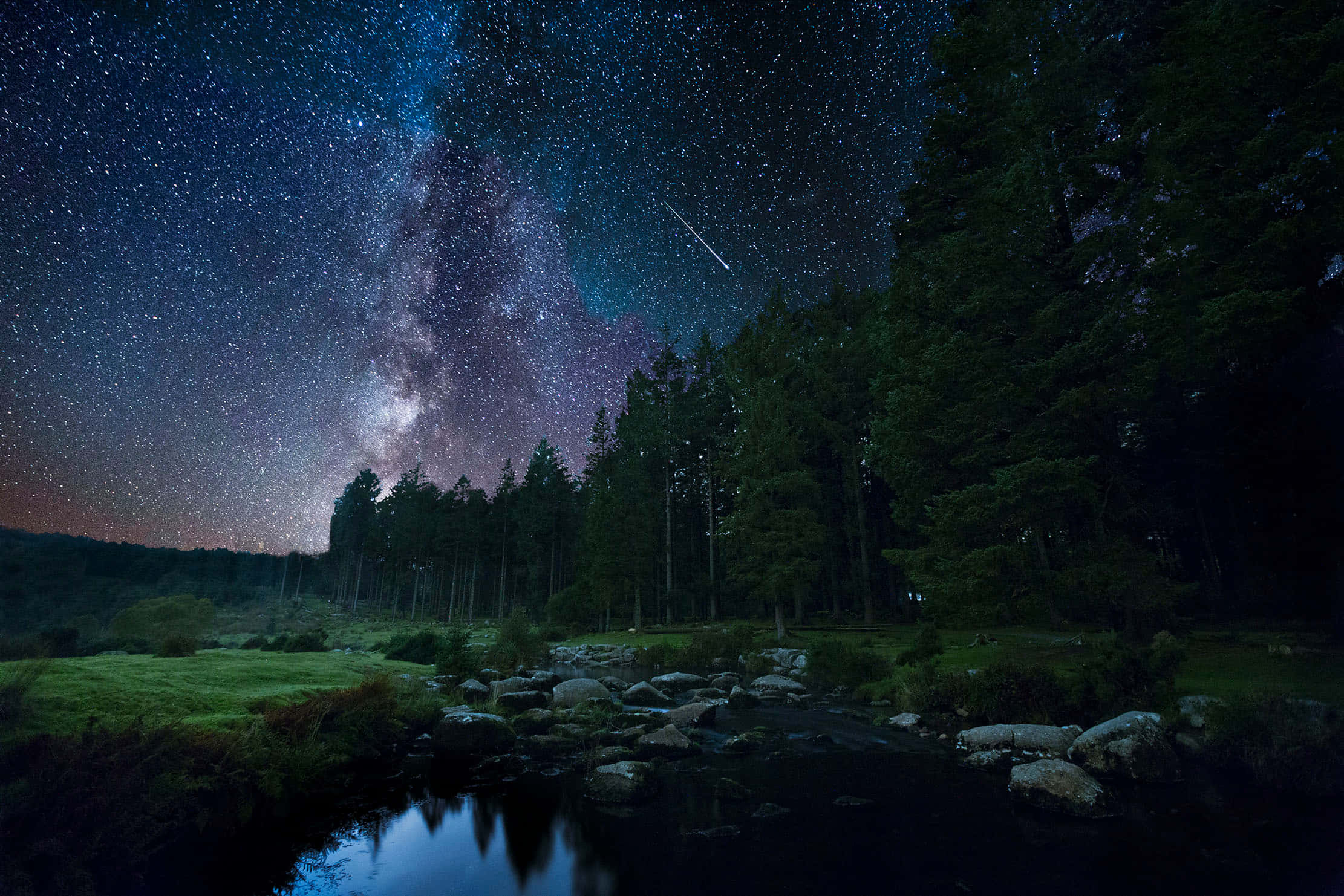 Night Time 桌布 壁紙 — 繁星點點的夜空，銀河與流星在黑暗森林和倒映宇宙的平靜河流上方拱起。