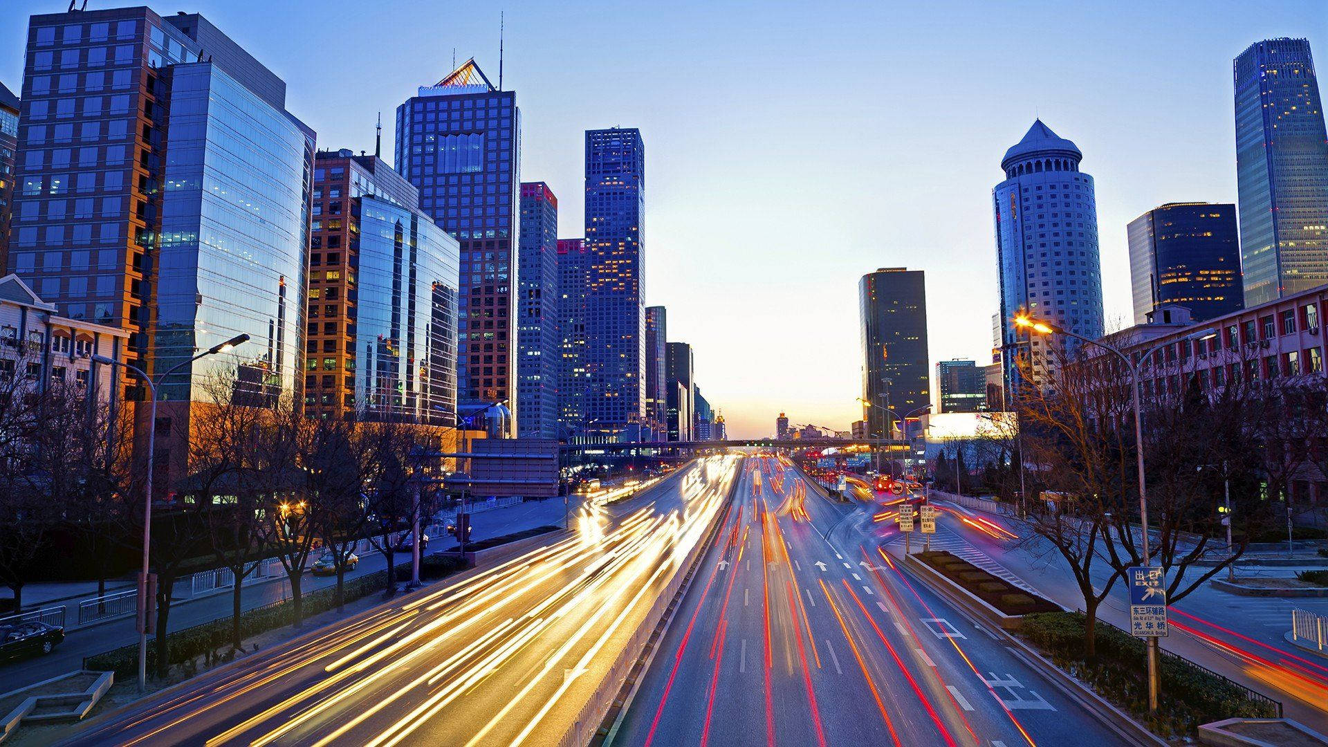 Beijing 桌布 壁紙 — 繁華的城市天際線在黃昏時分，車流在寬闊的大道上流動形成光跡。