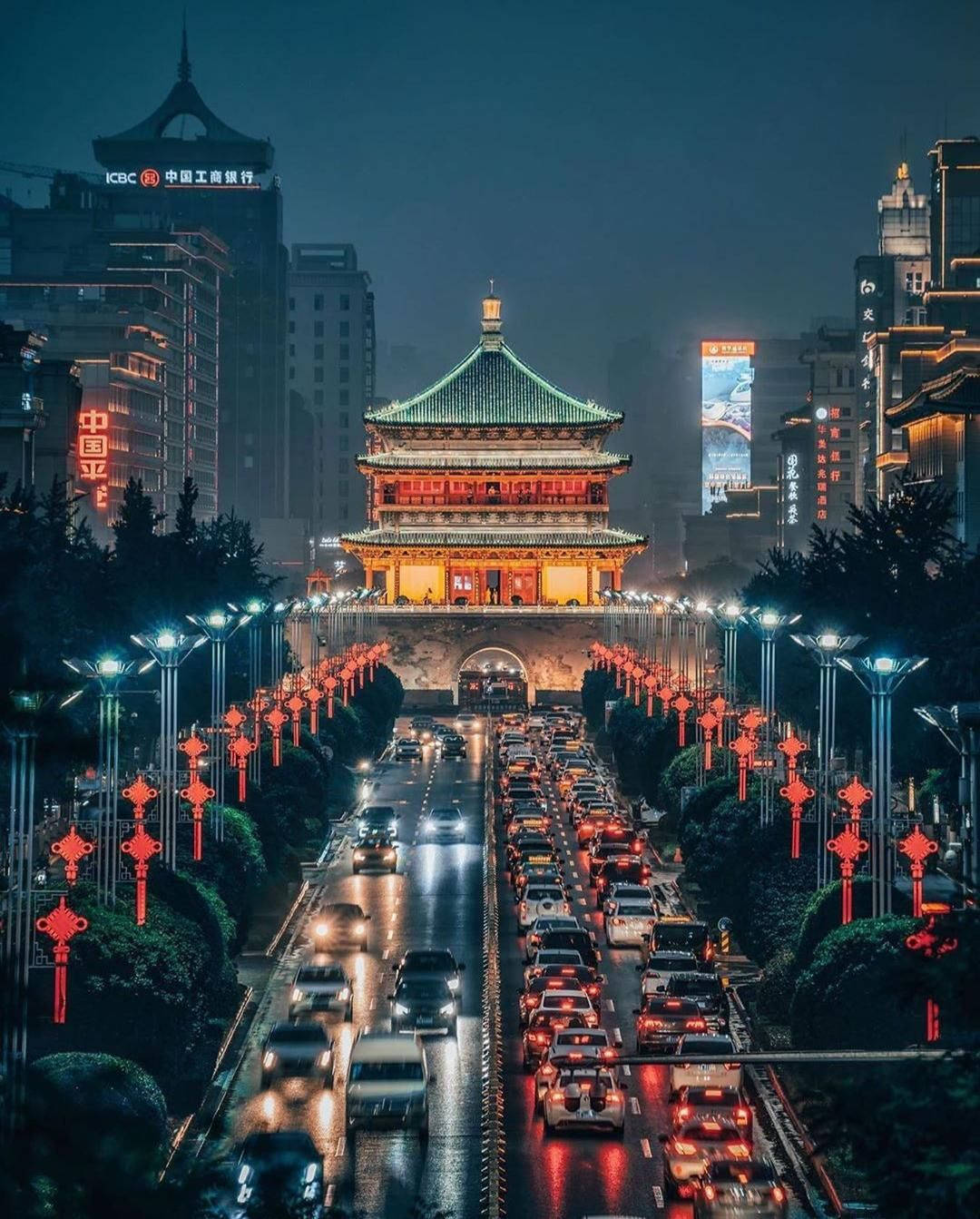 Xian 桌布 壁紙 — 繁華的夜景，一座燈火通明的傳統中式塔樓兩旁是車流和紅燈籠。