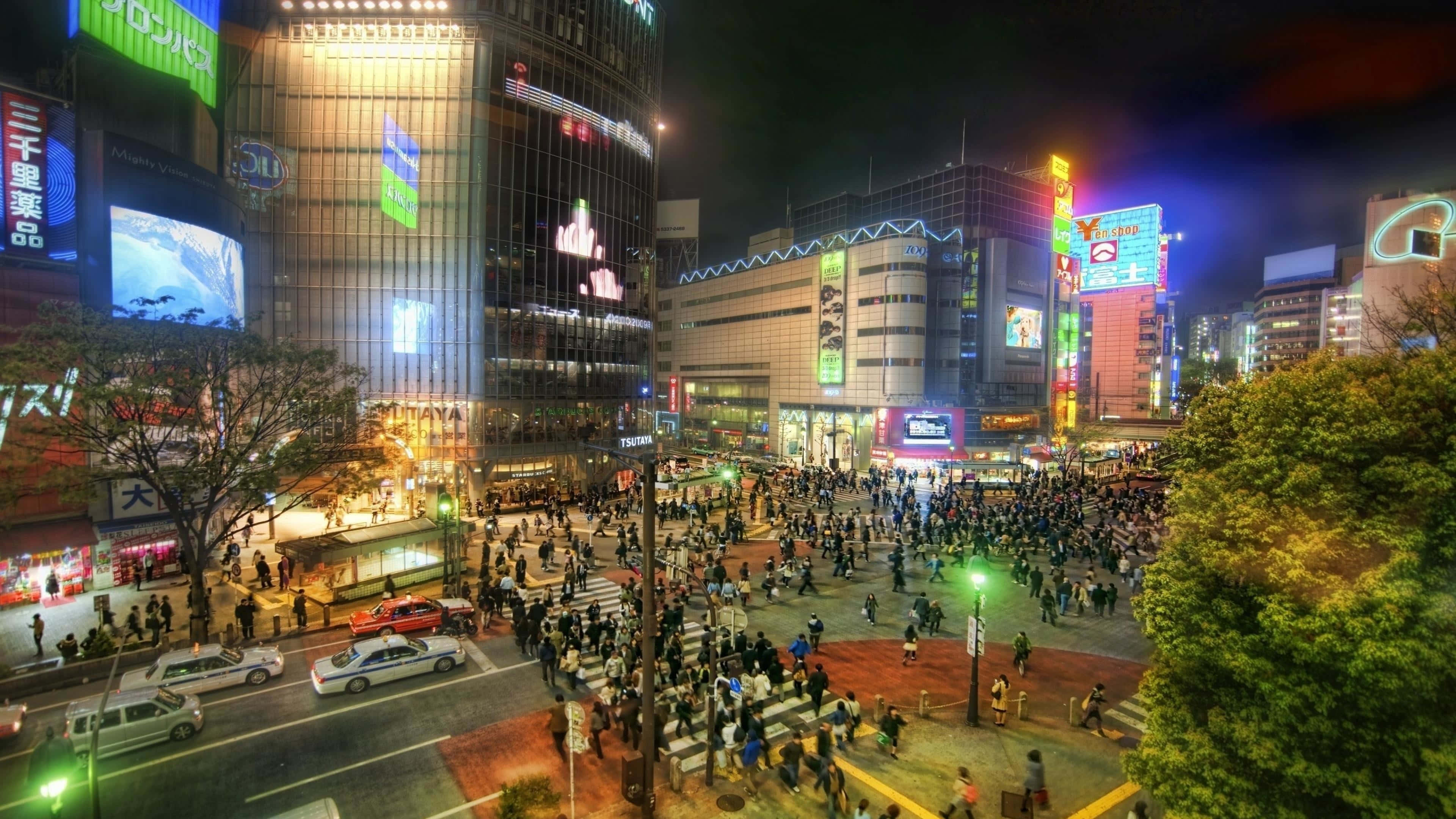 人物 桌布 壁紙 — 繁華的東京夜景，發光的霓虹燈招牌聳立在穿過繁忙十字路口的人群之上。