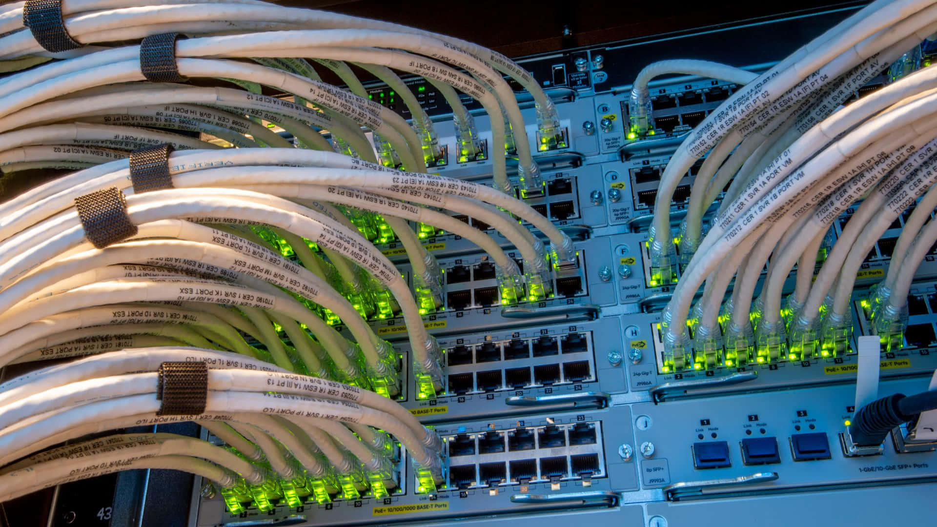 Gaming Servers 桌布 壁紙 — 纏繞的白色網路電纜帶有發光的綠色燈光，連接到數據中心的伺服器機架。