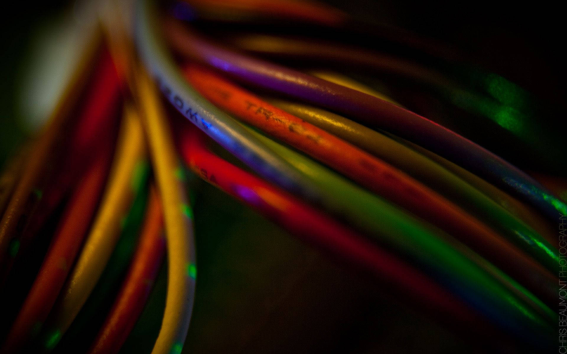 Electronics 桌布 壁紙 — 纏繞的鮮豔電線在黑暗背景下的霓虹燈光中發光的特寫。