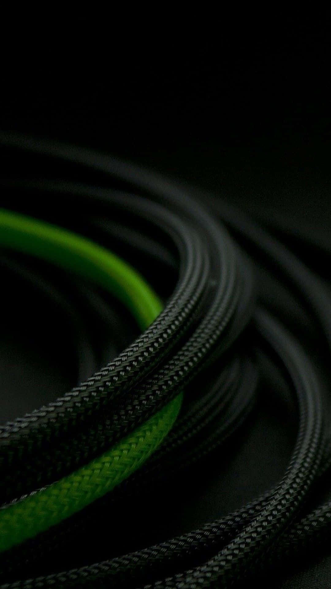 Green Phone 桌布 壁紙 — 纏繞的黑色編織線纜，帶有鮮豔的綠色條紋，在深黑色背景上柔和發光。