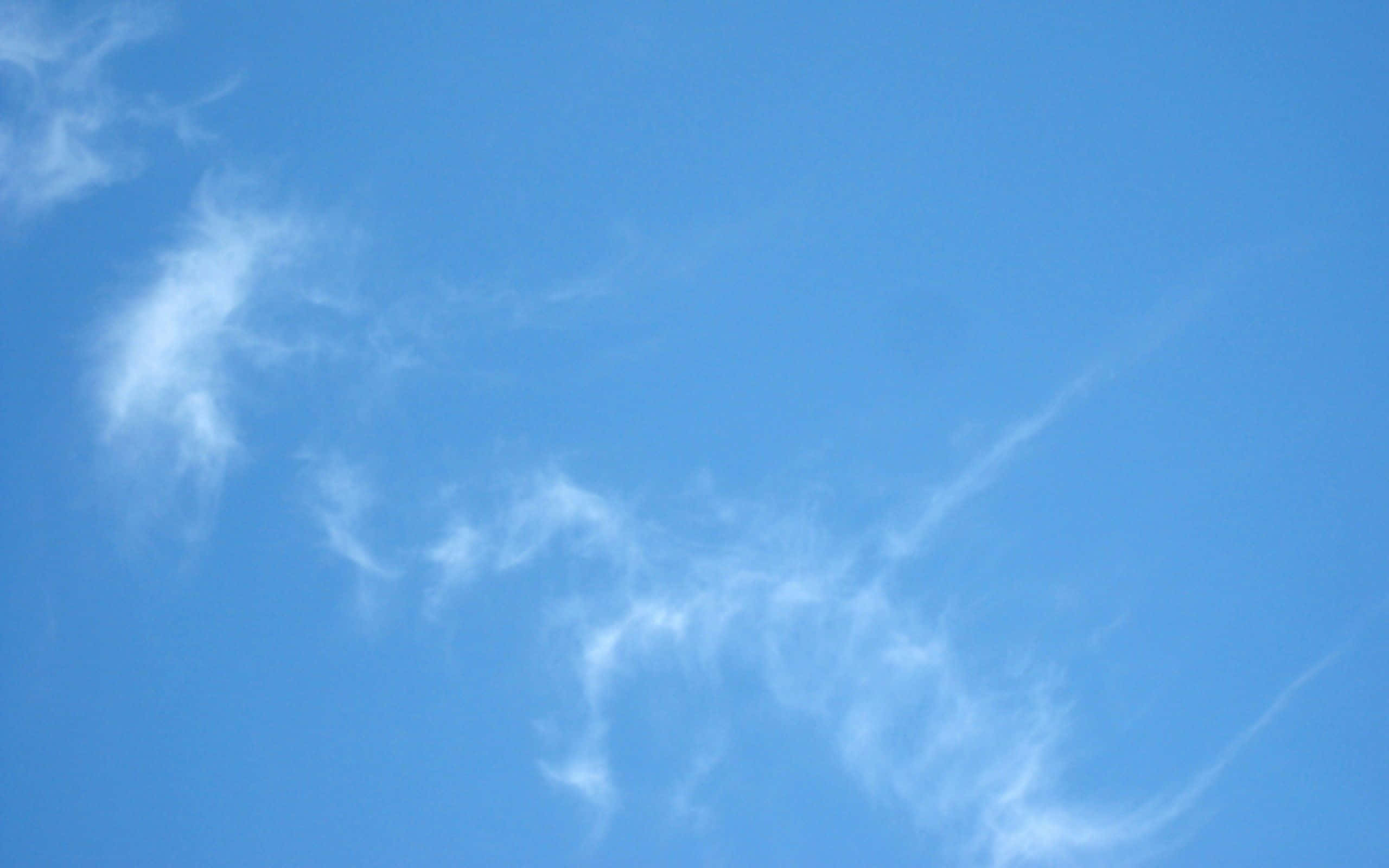 Blue Sky Aesthetic 桌布 壁紙 — 纖細的薄雲在廣闊清澈的藍天上飄移，呈現寧靜的自然景象。