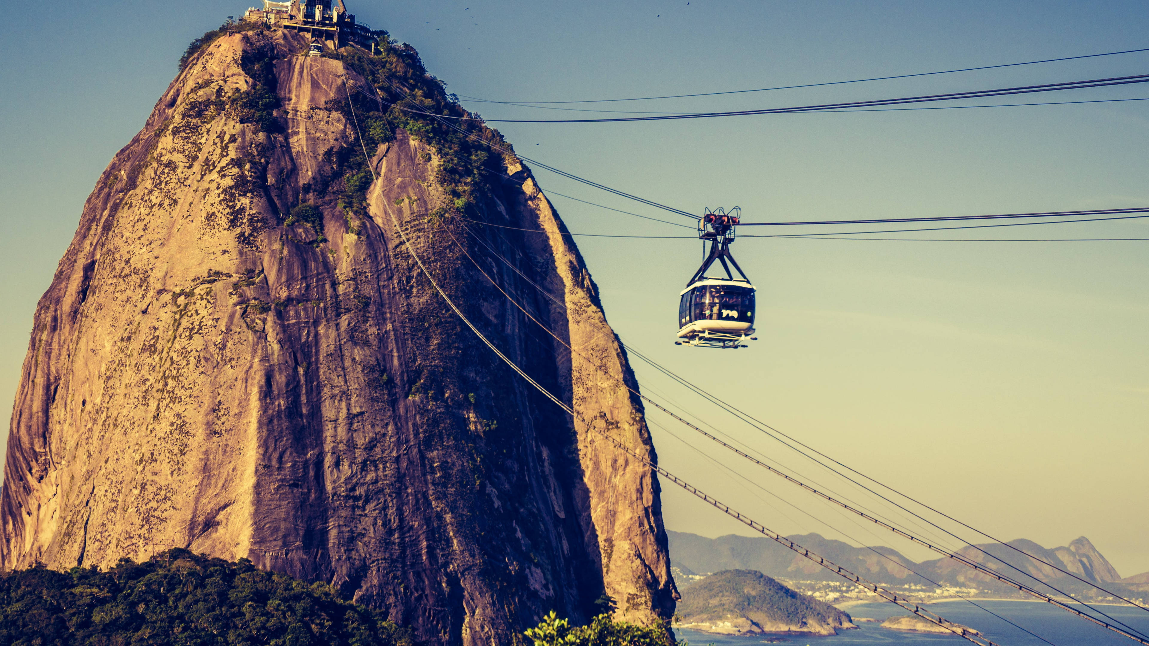 rio 桌布 壁紙 — 纜車在晴朗的天空下滑過糖麵包山的巨大花崗岩山峰。