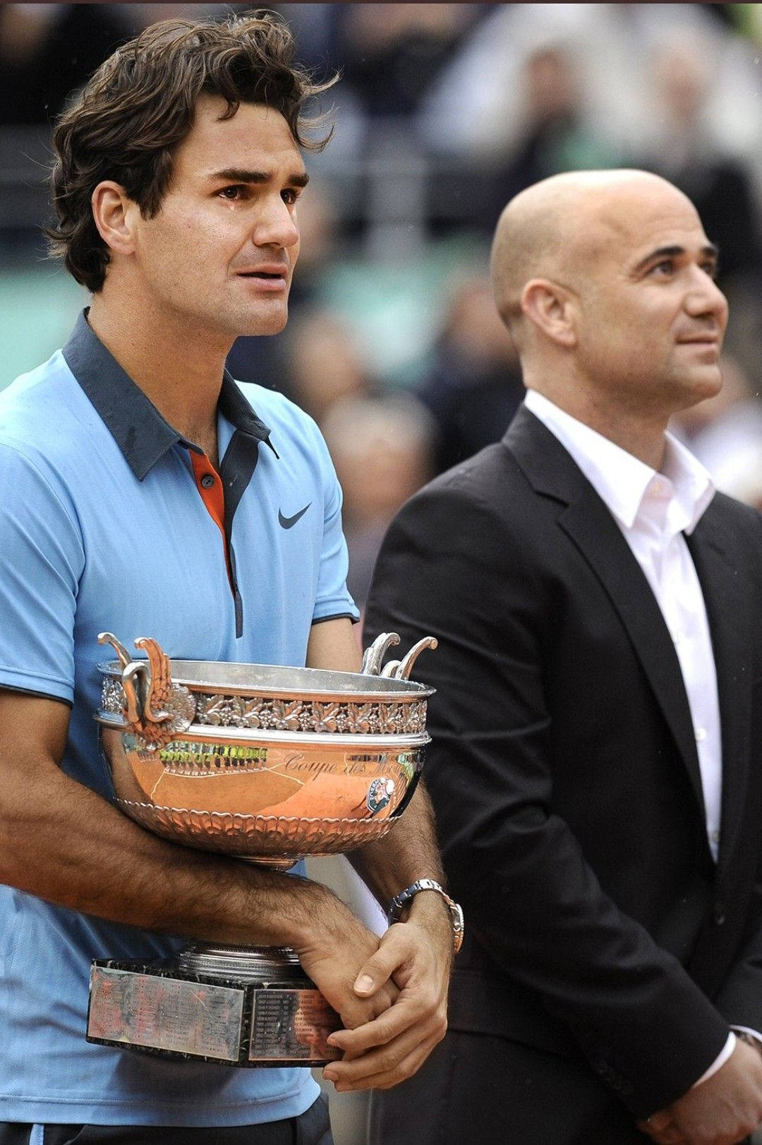 Trophy 桌布 壁紙 — 羅傑·費德勒在網球場上拿著閃閃發光的獎盃，與一位穿西裝的男子並肩而行。