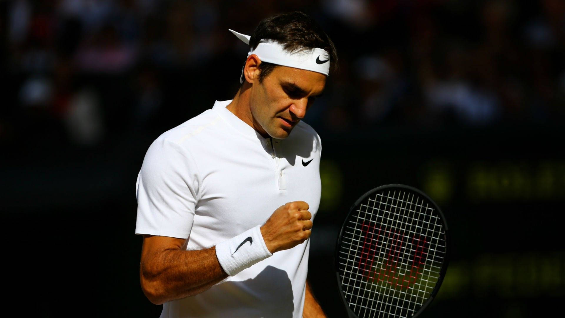 Wimbledon 桌布 壁紙 — 羅傑·費德勒在陽光明媚的球場上握緊拳頭，專注地拿著網球拍。