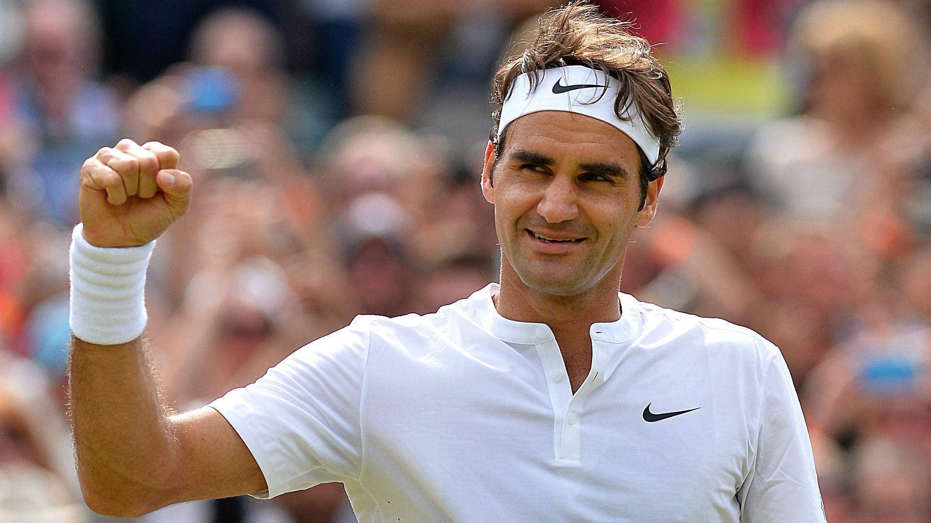 roger 桌布 壁紙 — 羅傑·費德勒身穿白色Nike裝備，在模糊的人群背景中握緊拳頭慶祝勝利。