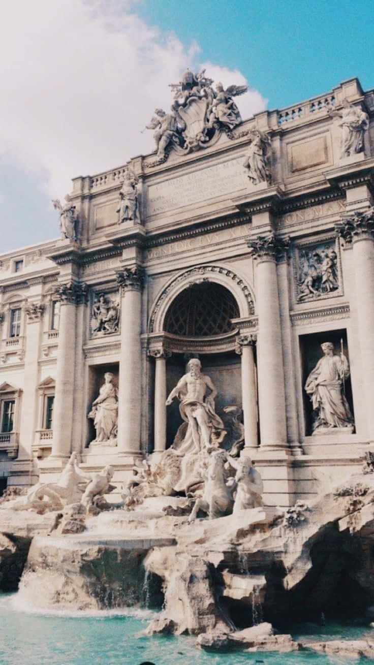Rome 桌布 壁紙 — 羅馬宏偉的巴洛克式特雷維噴泉，擁有大理石雕像和階梯式流水，在明亮的藍天下。