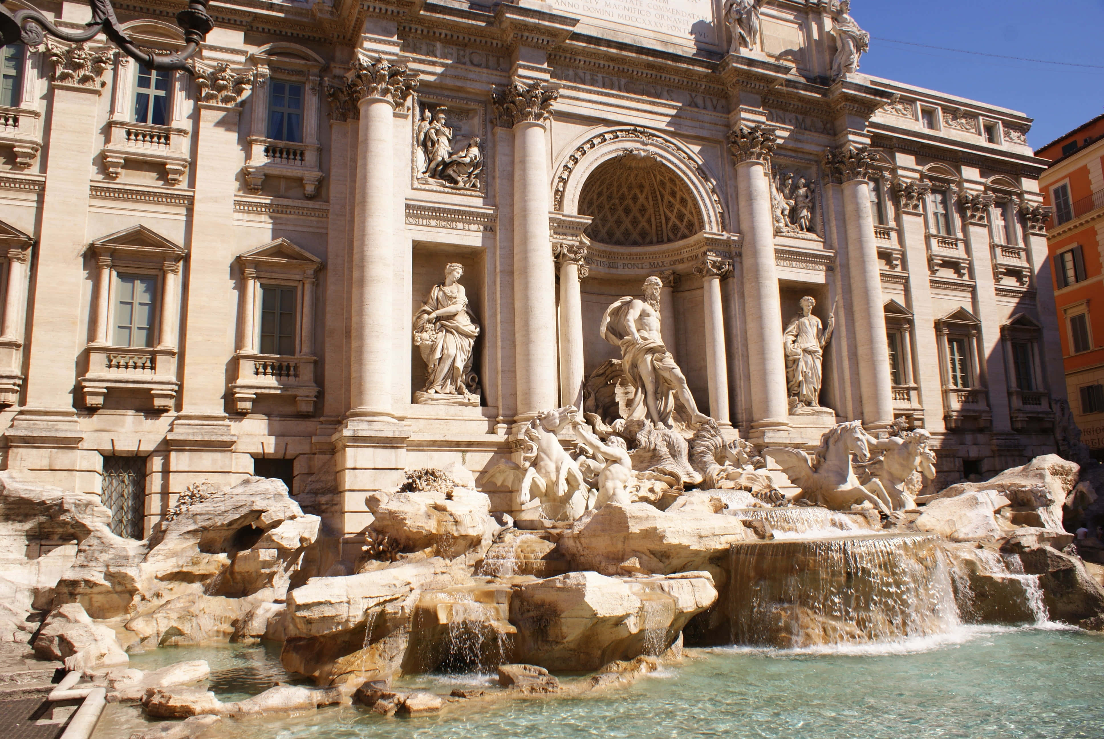 Rome 桌布 壁紙 — 羅馬特雷維噴泉沐浴在明亮的陽光下，水流傾瀉而下，裝飾華麗的巴洛克雕塑。