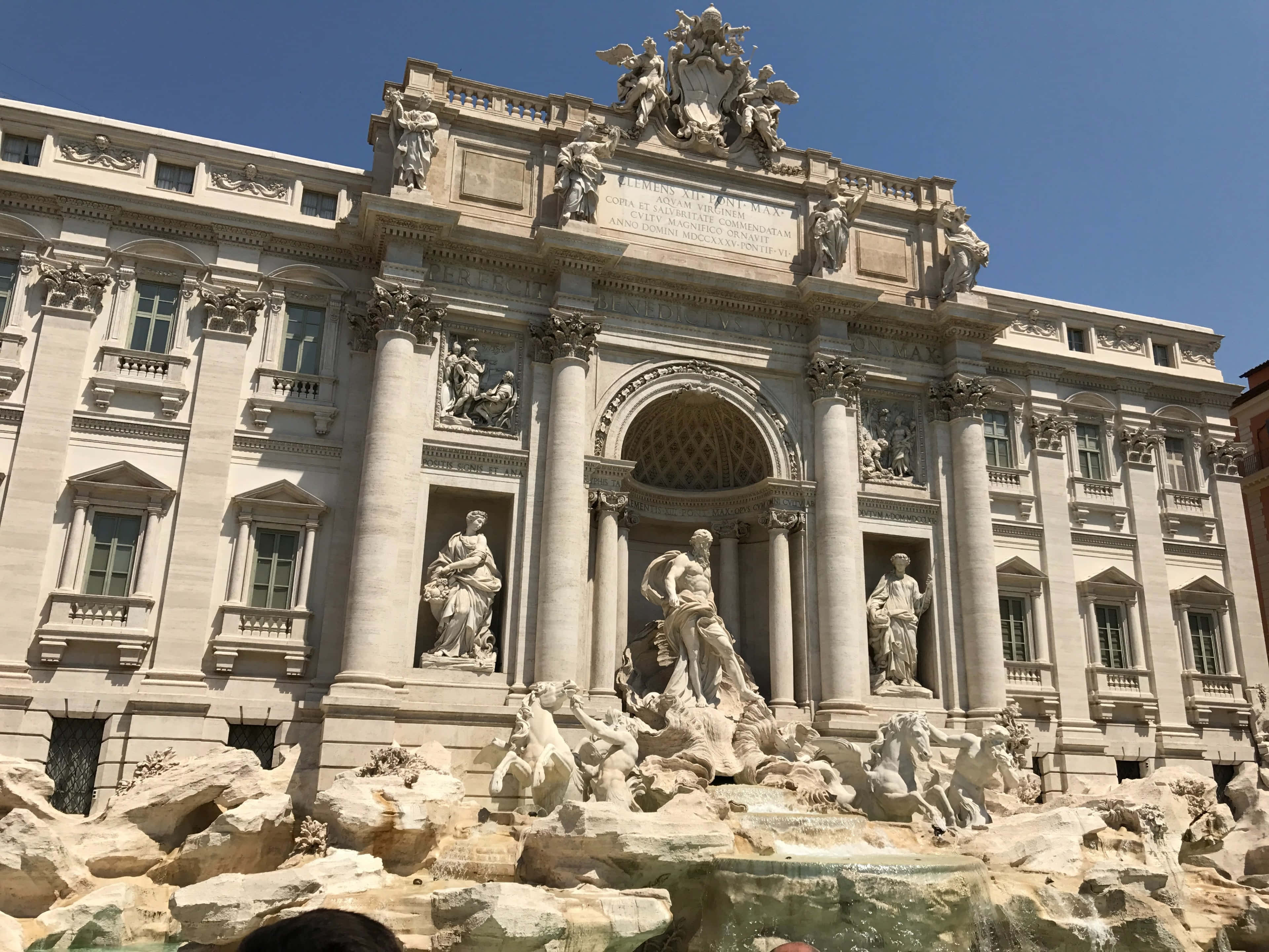 Rome 桌布 壁紙 — 羅馬的特雷維噴泉沐浴在明亮的陽光下，擁有複雜的巴洛克雕塑和流動的水，在清澈的藍天下。