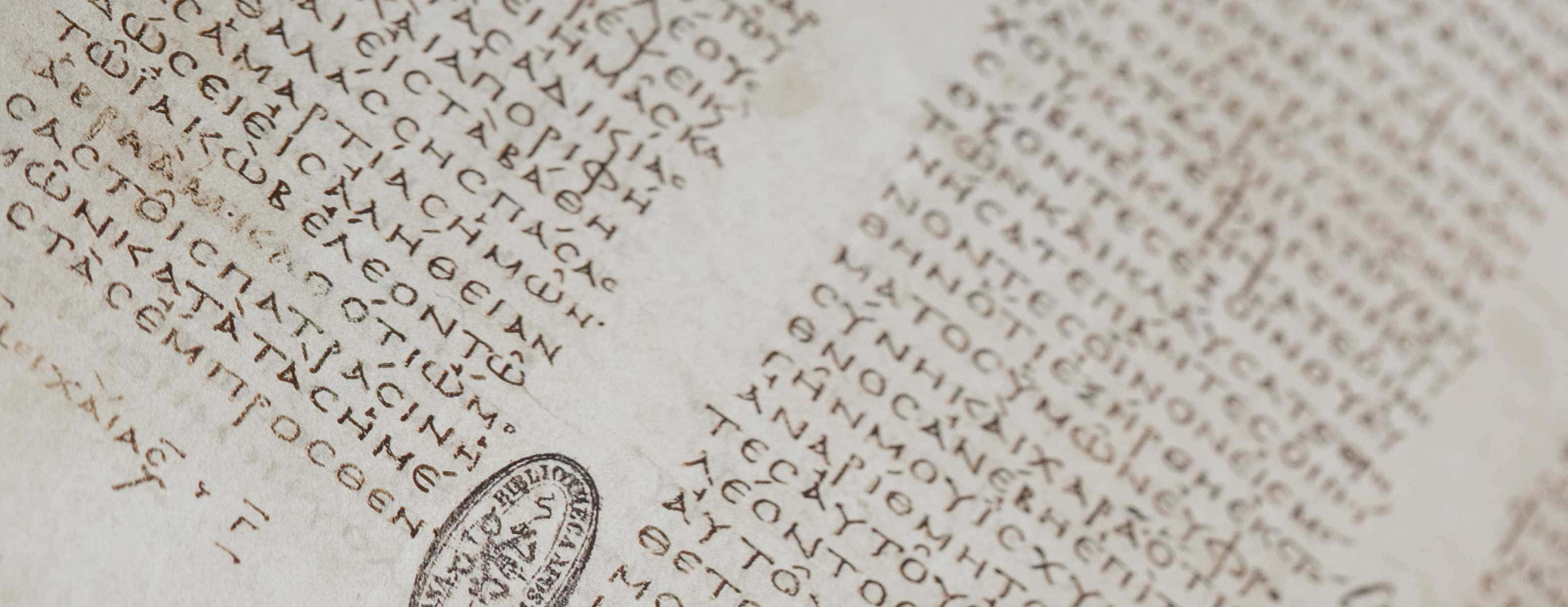 Scripture 桌布 壁紙 — 羊皮紙上古代希臘文字的近距離特寫，角落有一個褪色的印章浮雕。