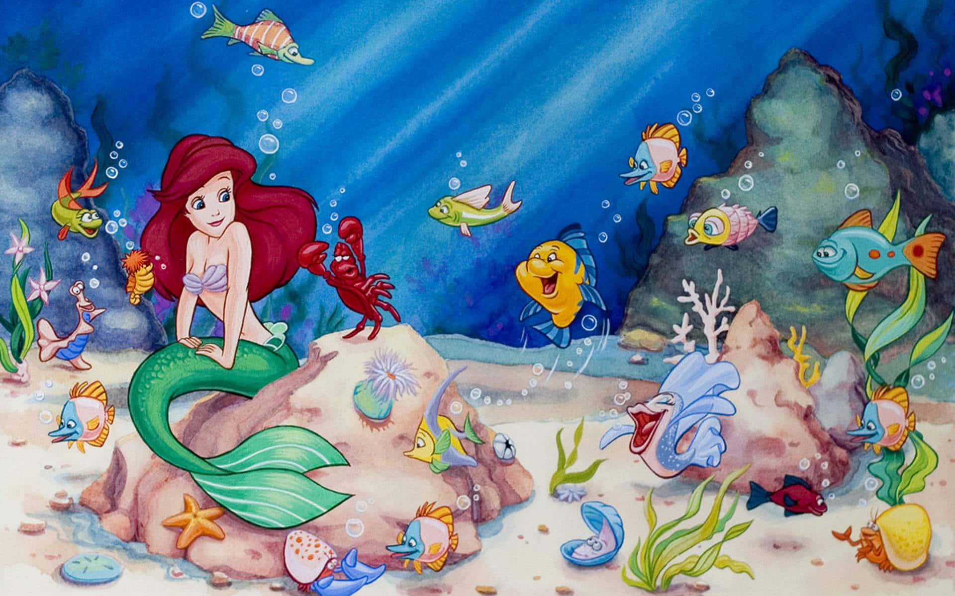 little mermaid 桌布 壁紙 — 美人魚艾莉爾坐在岩石上，周圍是色彩繽紛的魚類和珊瑚，呈現充滿活力的海底場景。