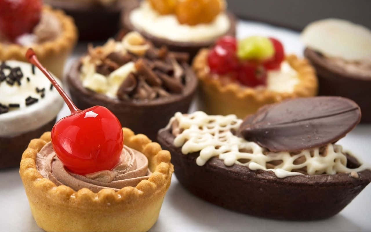 Pastry 桌布 壁紙 — 美味的迷你巧克力與奶油塔拼盤，上面放有櫻桃、堅果和新鮮莓果。