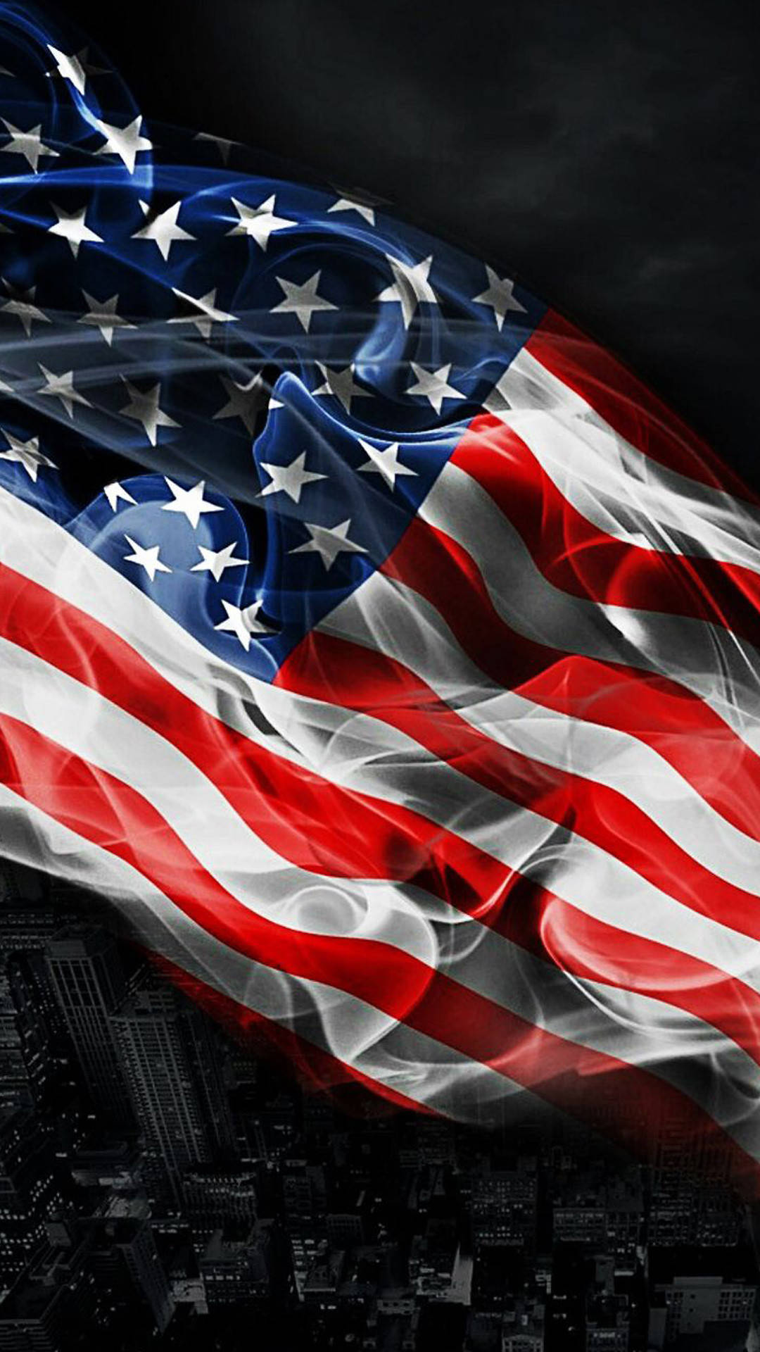 Military American Flag 桌布 壁紙 — 美國國旗在夜間黑暗的城市景觀上戲劇性地飄揚，下方有閃爍的燈光。