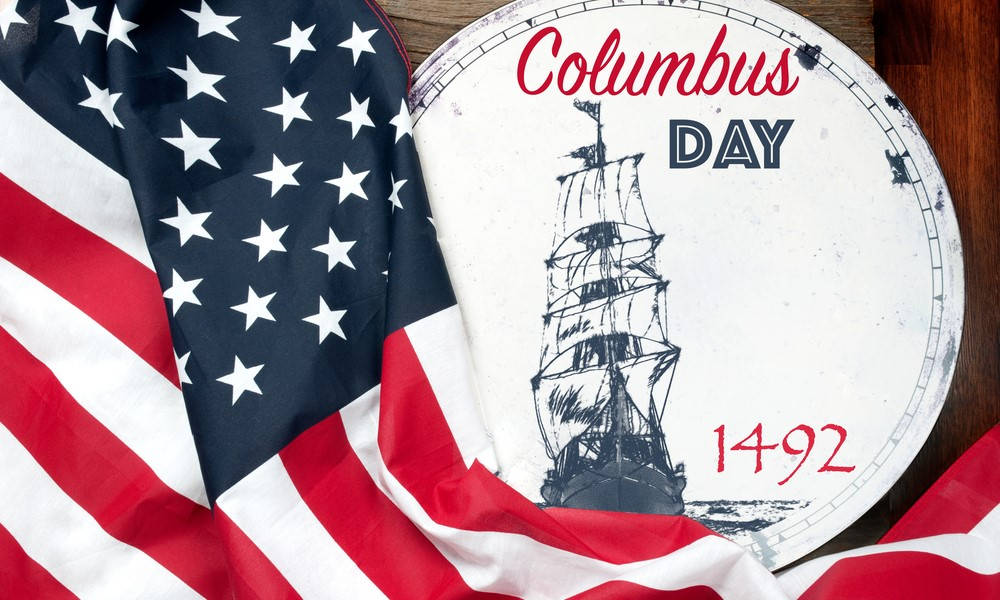 Columbus Day 桌布 壁紙 — 美國國旗披在一個復古哥倫布日牌匾上，牌匾上有船和1492年，置於木質表面。