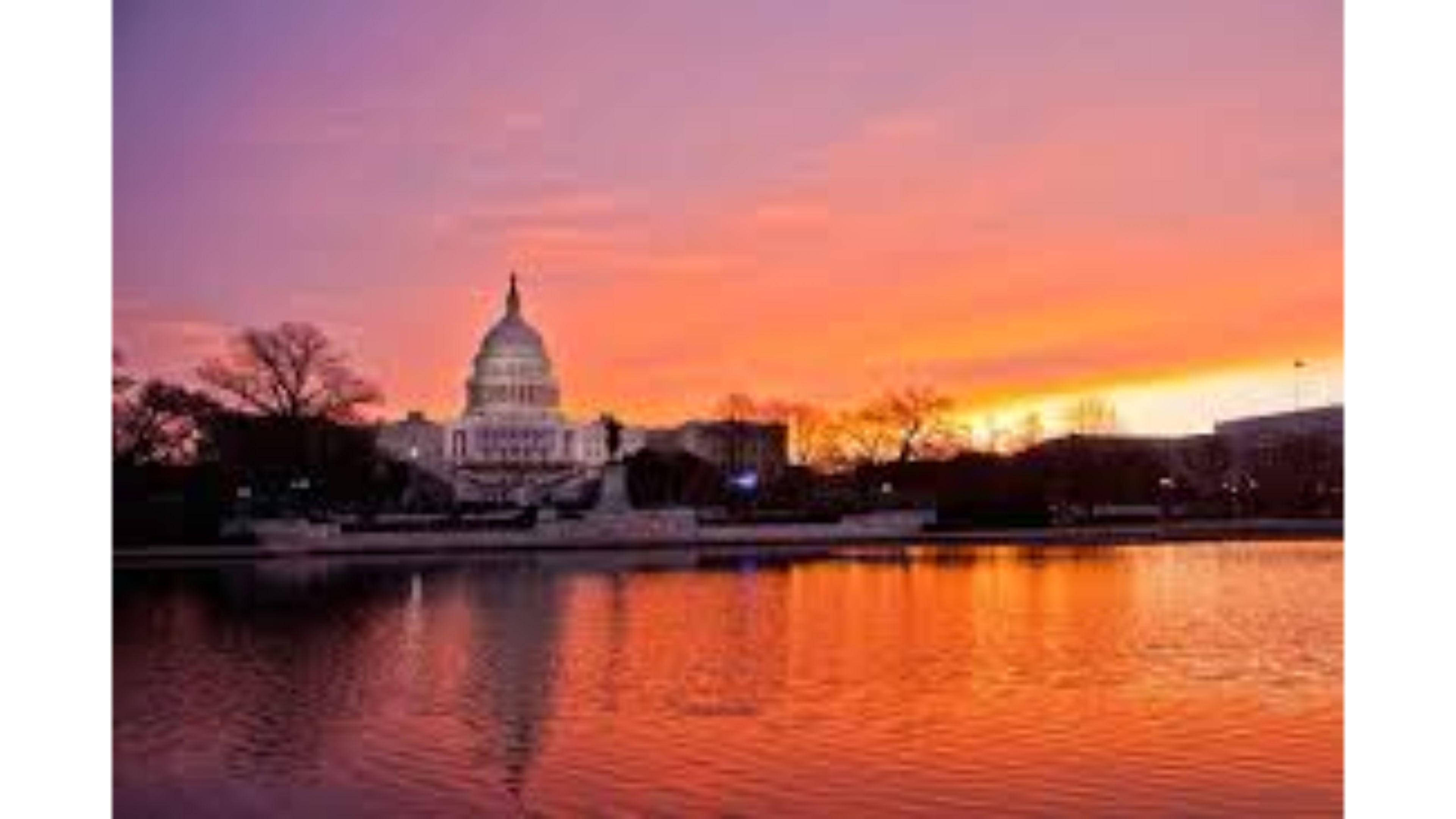 Washington 桌布 壁紙 — 美國國會大廈在充滿活力的橙色和粉紅色日落天空下，倒映在平靜的水面上。