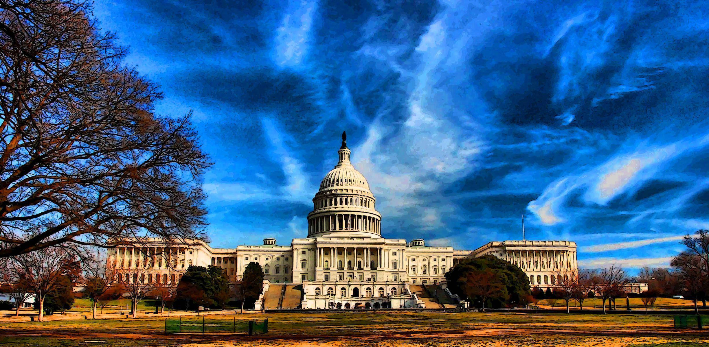 Washington 桌布 壁紙 — 美國國會大廈在鮮豔的藍天白雲下雄偉矗立，周圍是光禿的冬季樹木和修剪整齊的草坪。