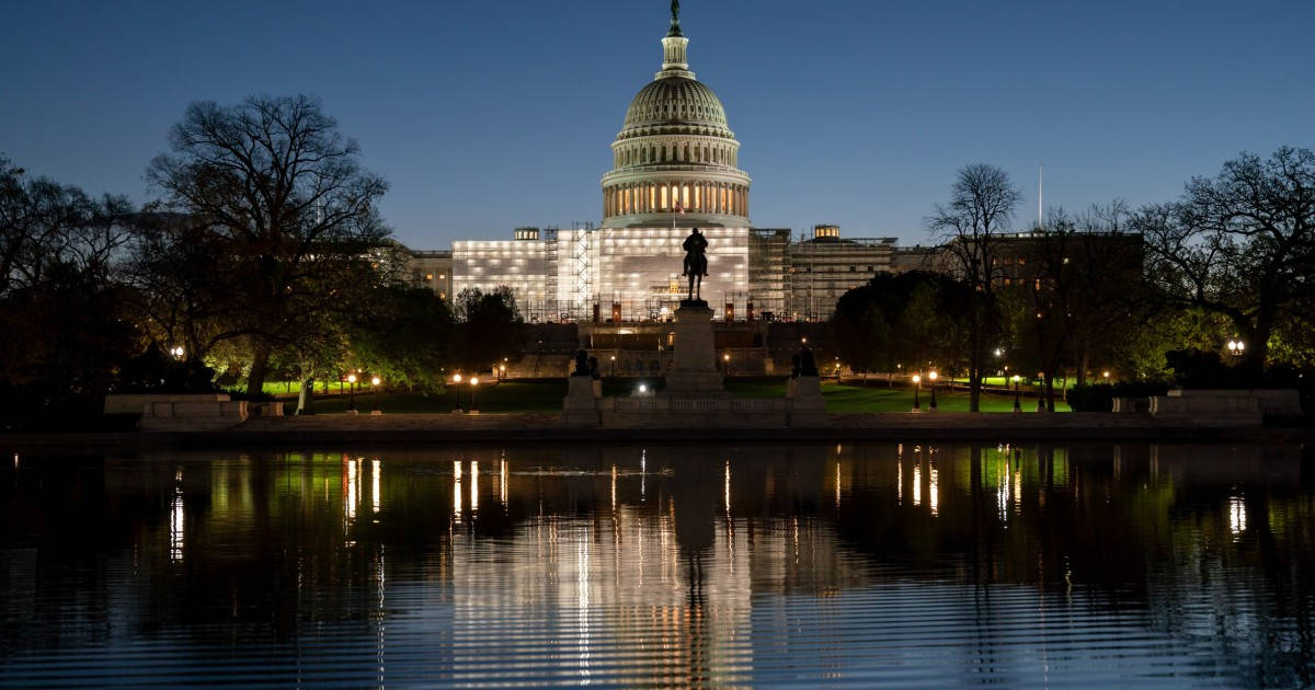 Capitol Hill 桌布 壁紙 — 美國國會大廈在黃昏時溫暖地發光，其圓頂和燈光完美地倒映在倒影池平靜的水面上。
