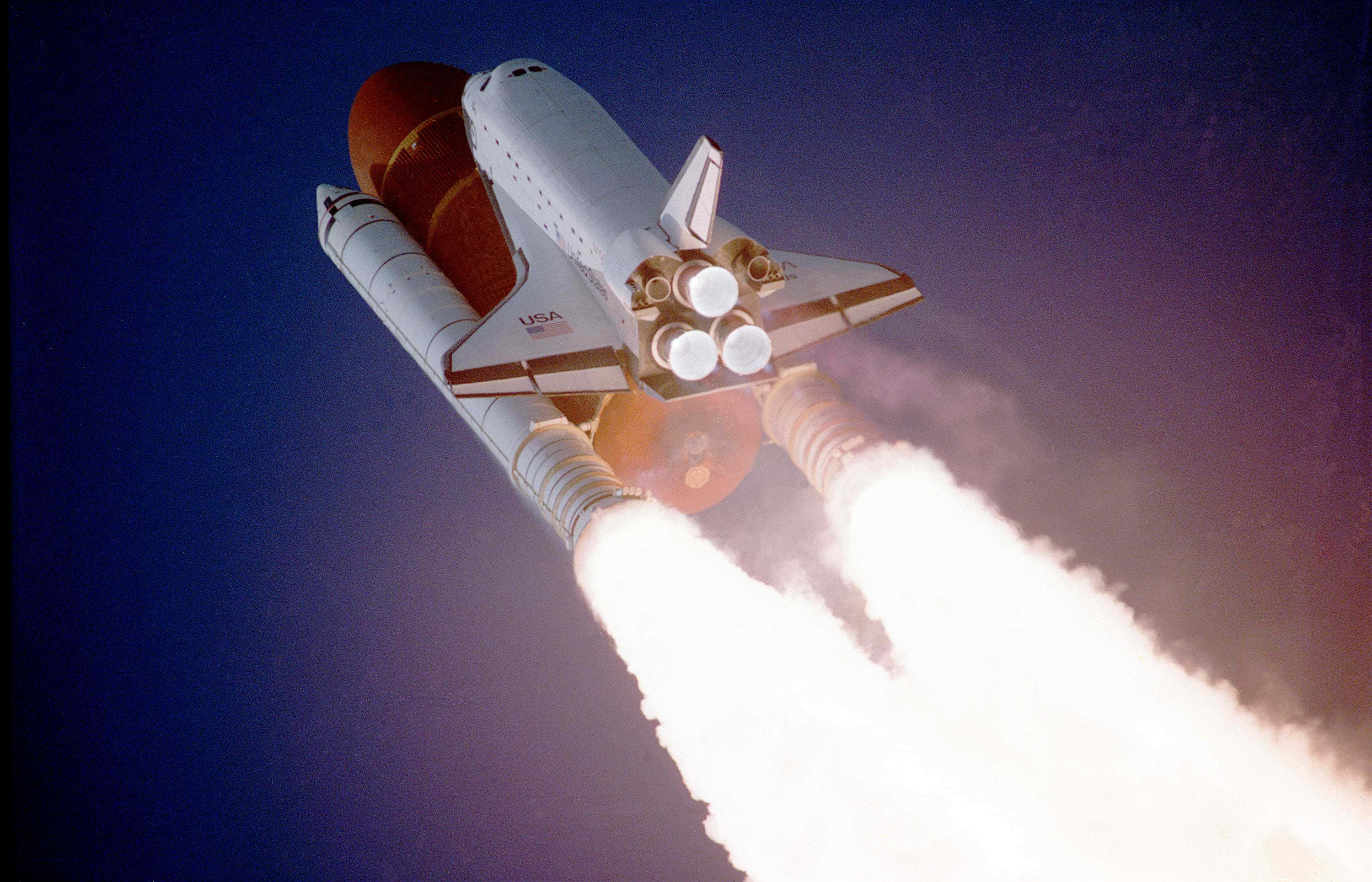 space shuttle 桌布 壁紙 — 美國太空總署的太空梭在夜空中強力攀升，身後拖著明亮熾熱的尾焰。