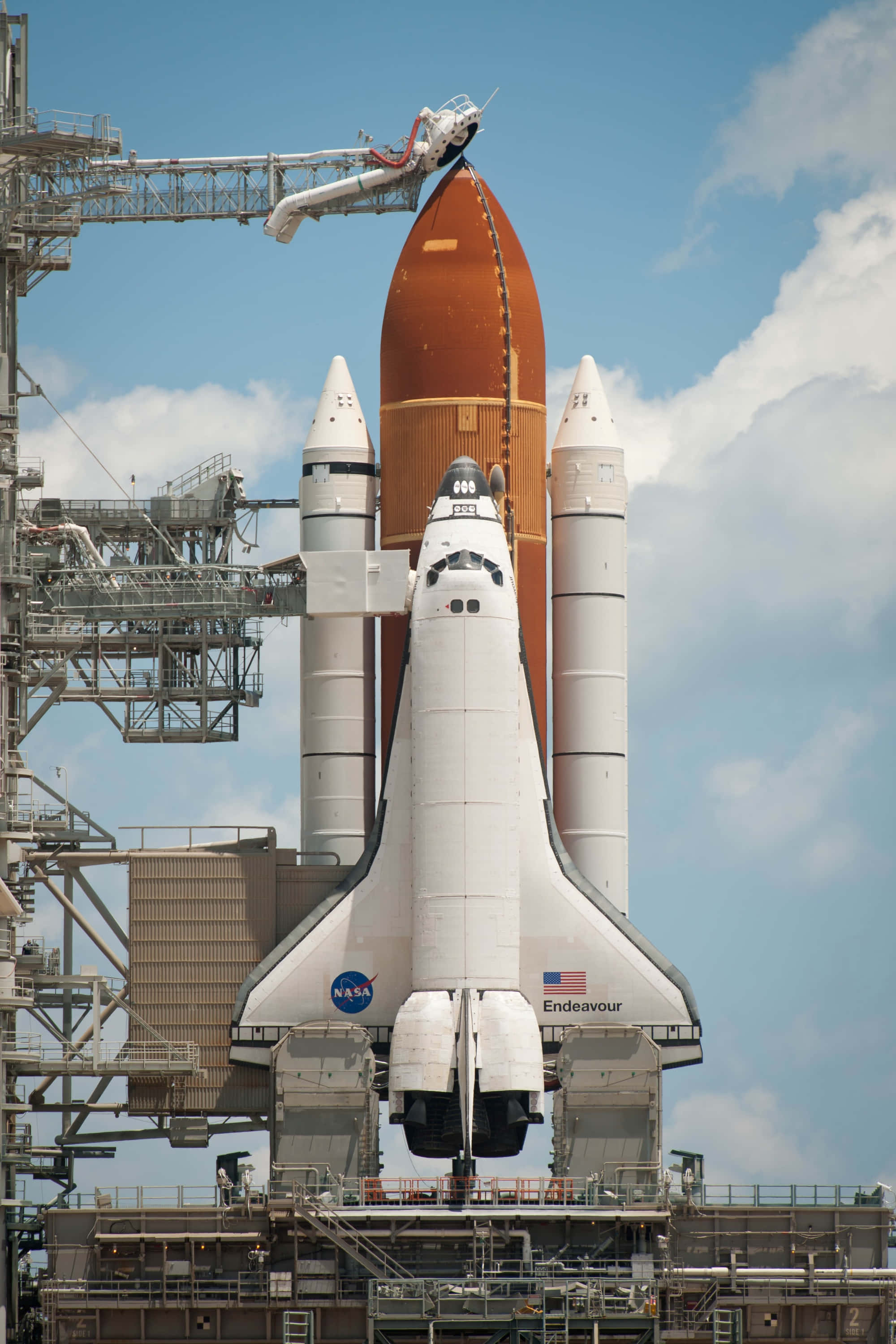 NASA 動態圖片 桌布 壁紙 — 美國太空總署的奮進號太空梭在晴朗藍天下，配備橙色外部燃料箱和白色固體火箭助推器，矗立在發射台上。