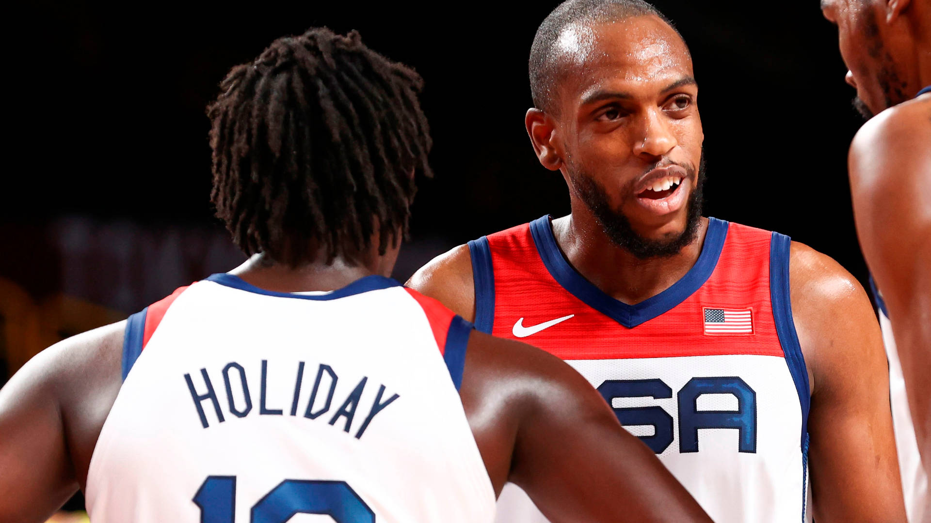 Khris Middleton 桌布 壁紙 — 美國籃球運動員克里斯保羅在明亮的場館燈光下，在比賽中與隊友喬許哈勒戴熱烈交談。