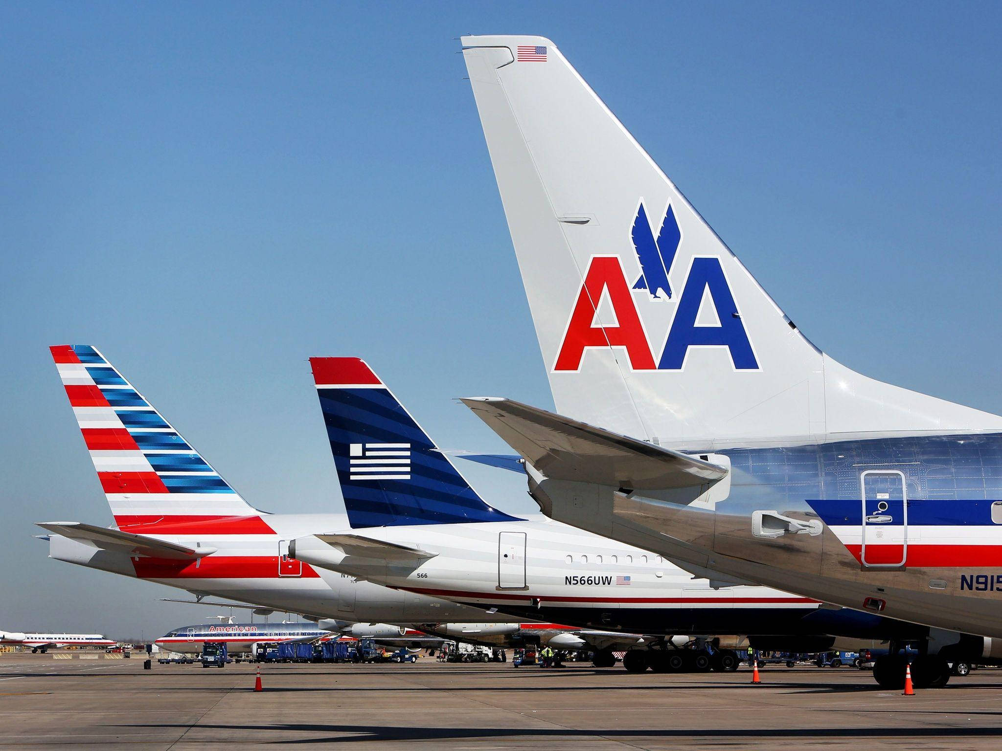 Airlines 桌布 壁紙 — 美國航空及其他航空公司的機尾在晴朗藍天下的陽光停機坪上高高聳立。